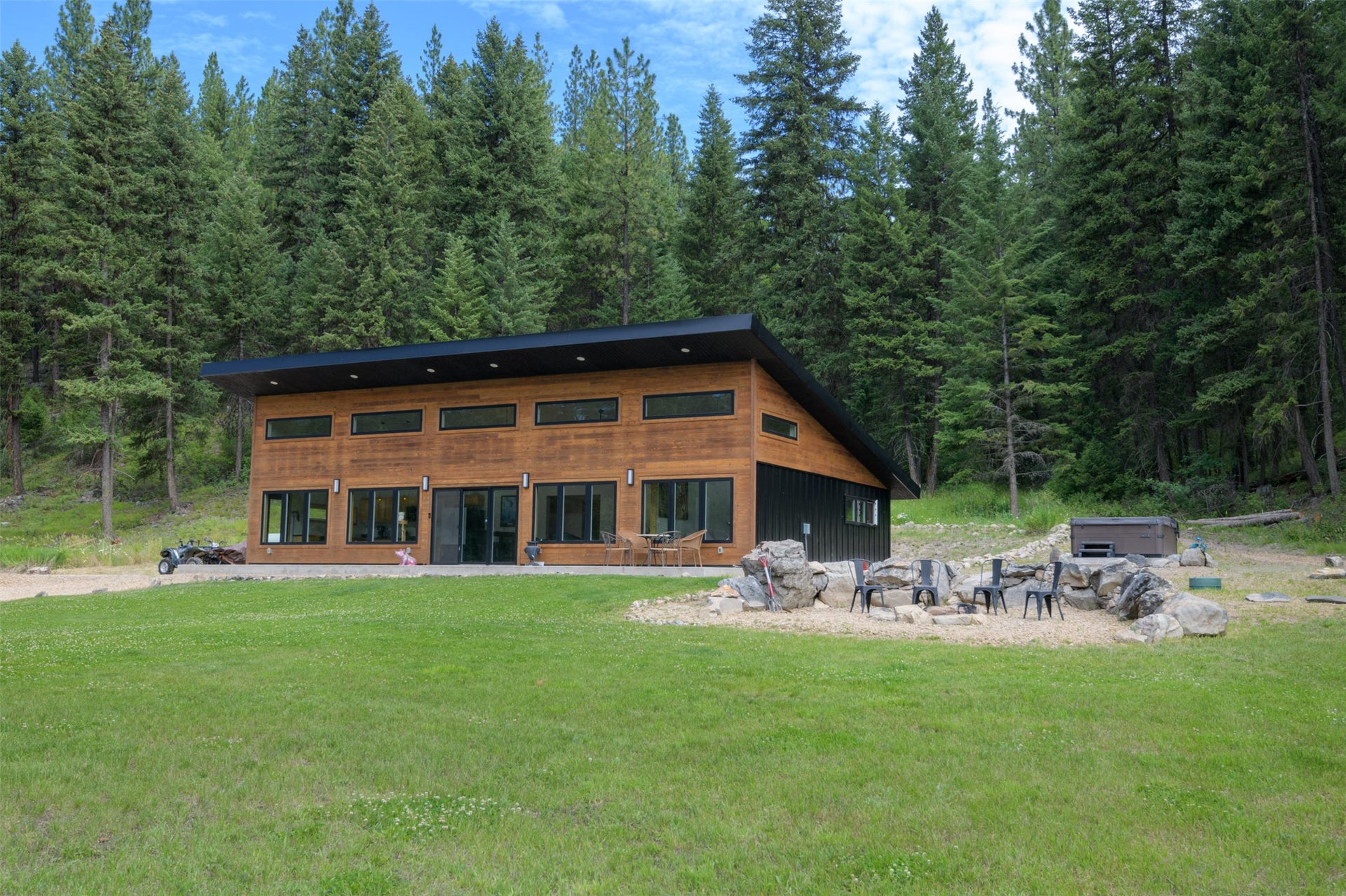 Modern architectural design featuring extensive window placement, a flat roofline, and wood-finish siding