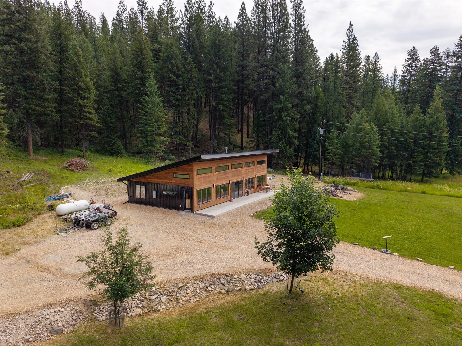 Modern exterior with wood-finish siding, extensive window placement, and a sloped roofline