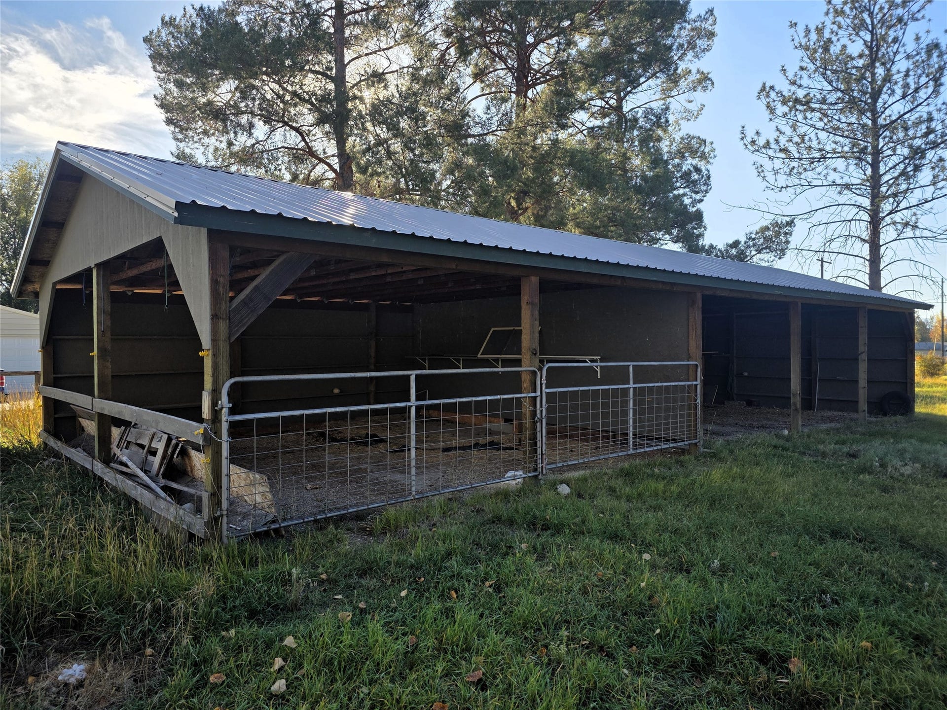 115 Ricketts Road, Hamilton, MT 59840 Open-sided barn structure with a metal roof, wood support beams, and a metal-paneled back wall