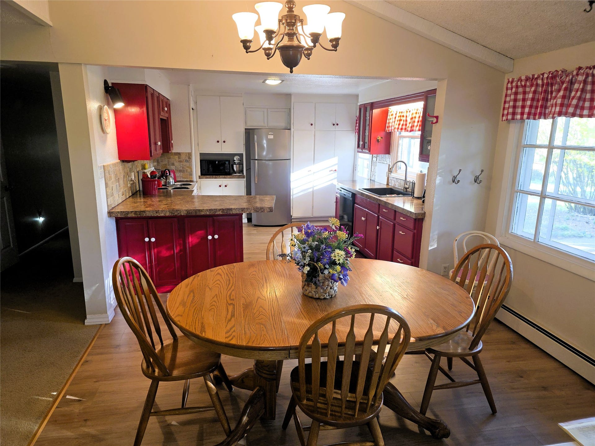 115 Ricketts Road, Hamilton, MT 59840 Kitchen with red and white cabinetry, stone-look countertops, stainless steel appliances, and a wood-finish flooring