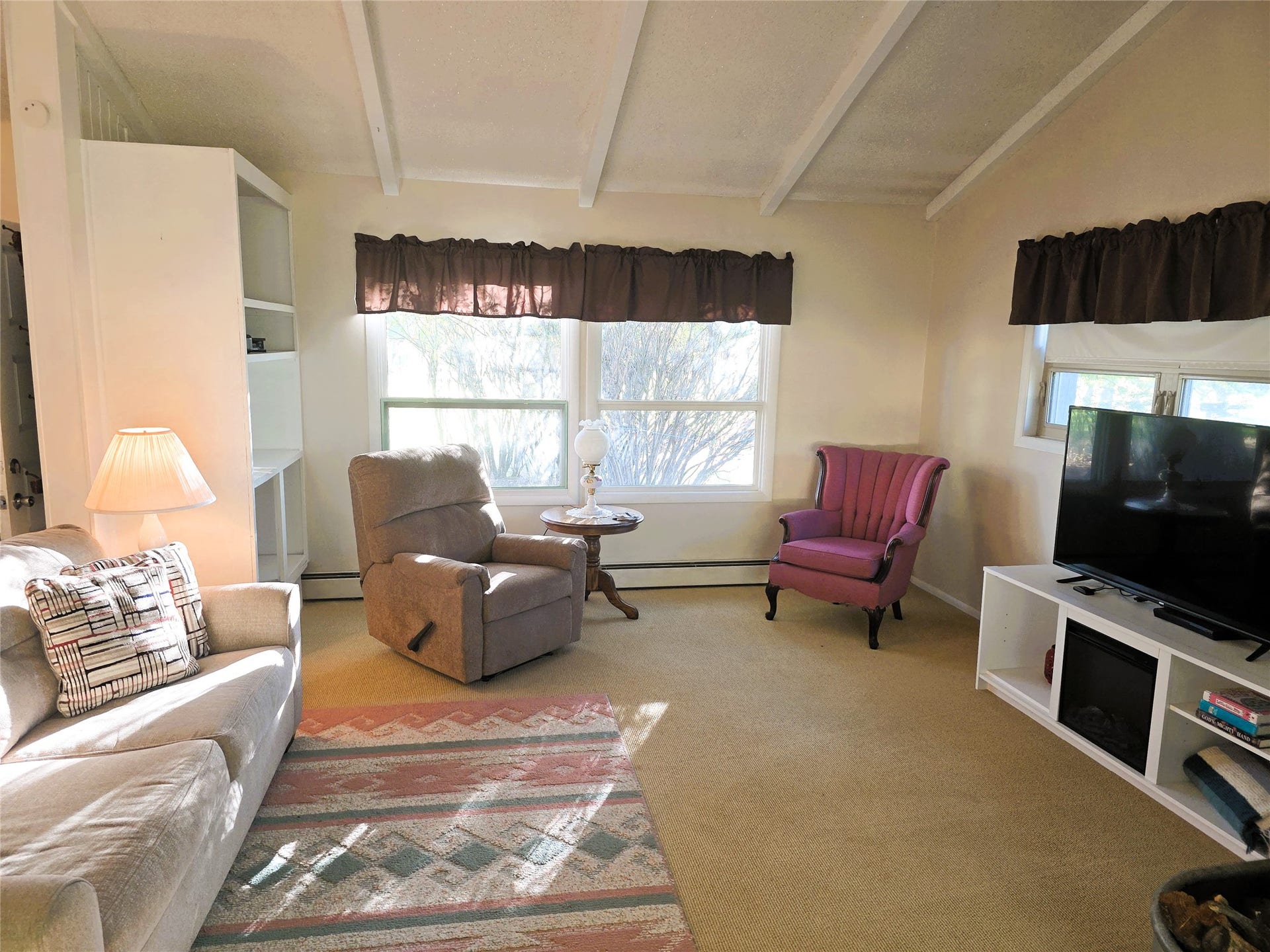 115 Ricketts Road, Hamilton, MT 59840 Living space with exposed ceiling beams, built-in shelving, and multiple windows