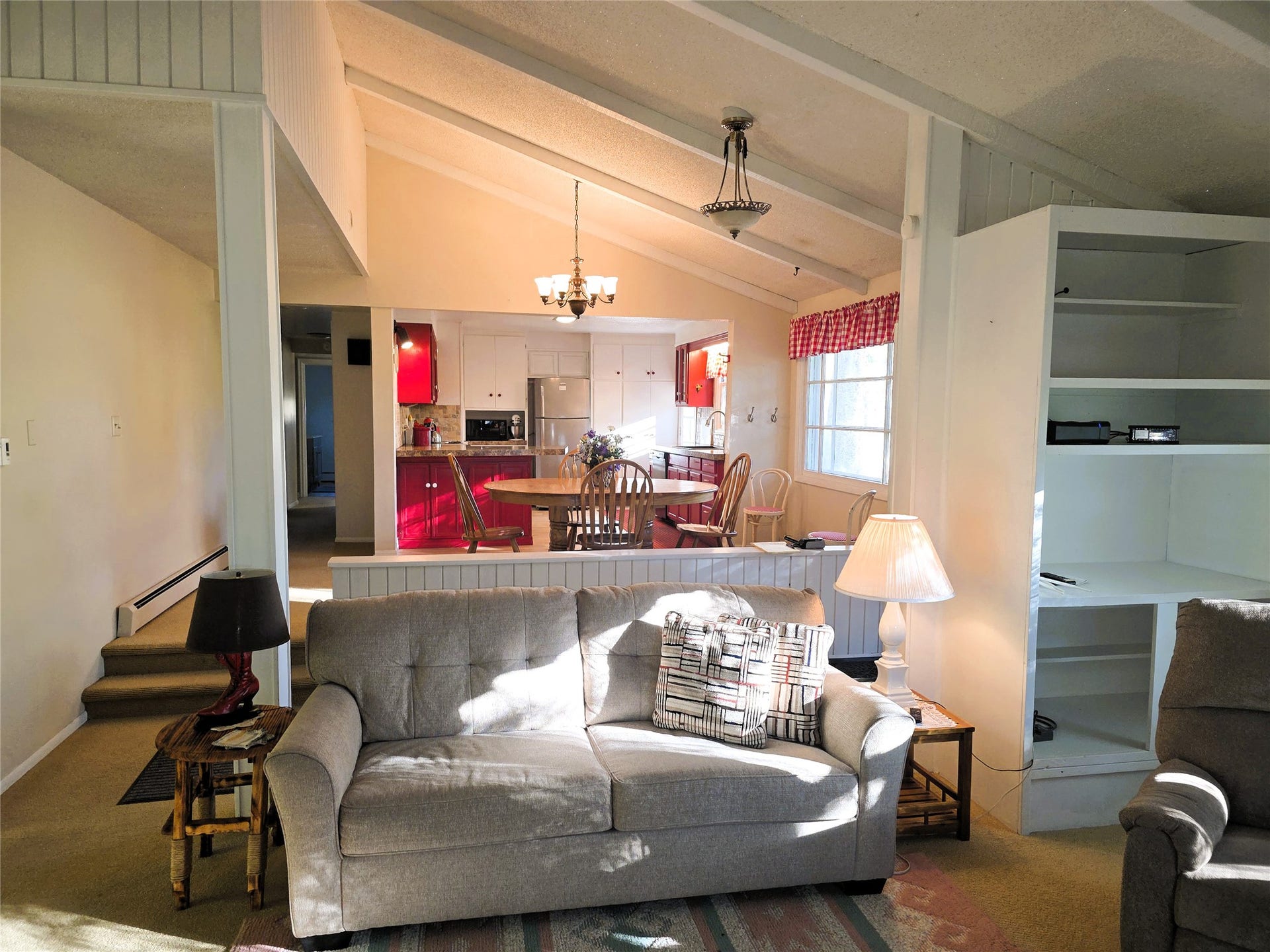 115 Ricketts Road, Hamilton, MT 59840 Vaulted ceilings with exposed beams, built-in shelving, and a dining area with a chandelier