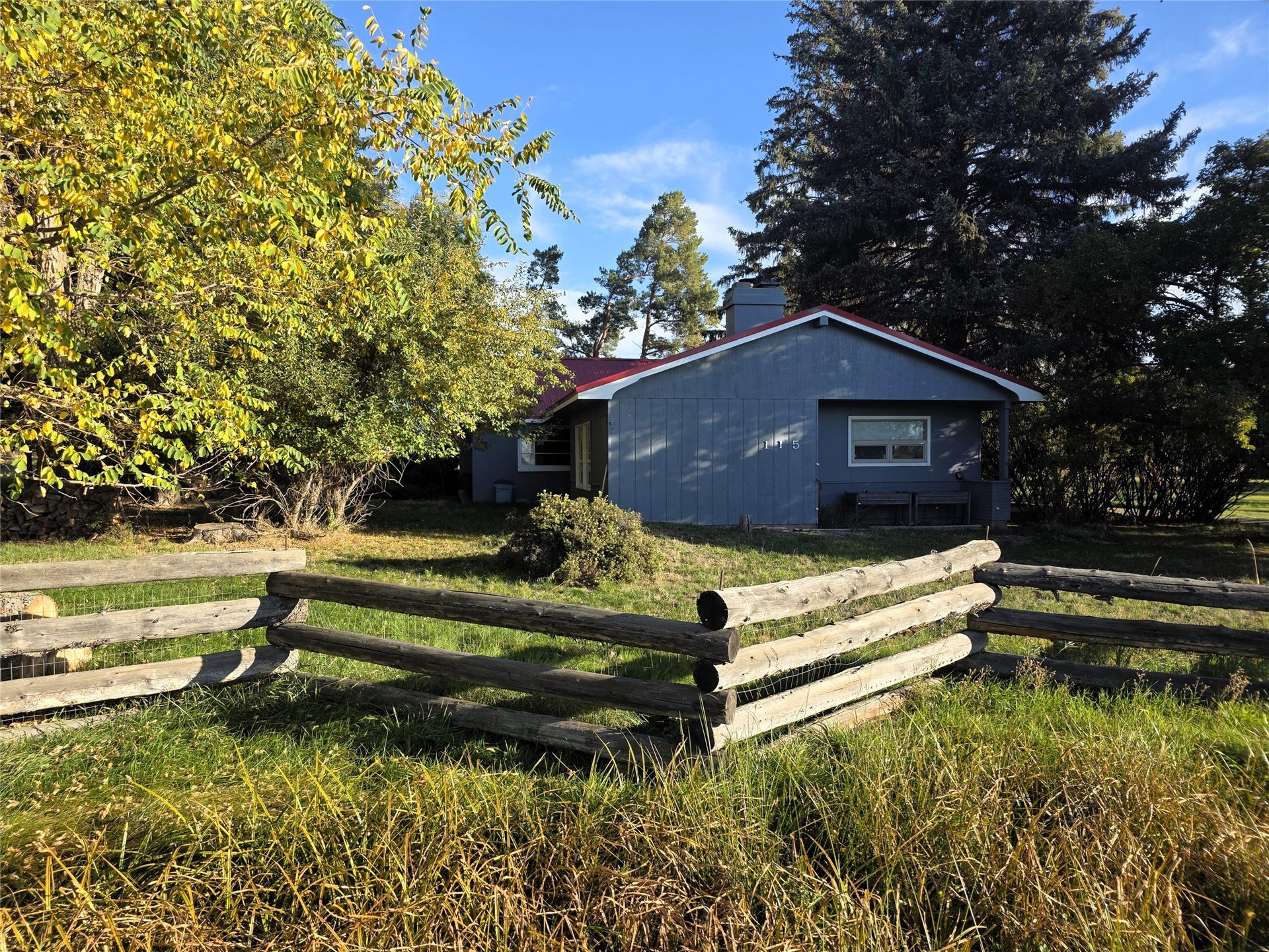 115 Ricketts Road, Hamilton, MT 59840 Single-story residence with blue siding and a red roof, featuring a covered entry