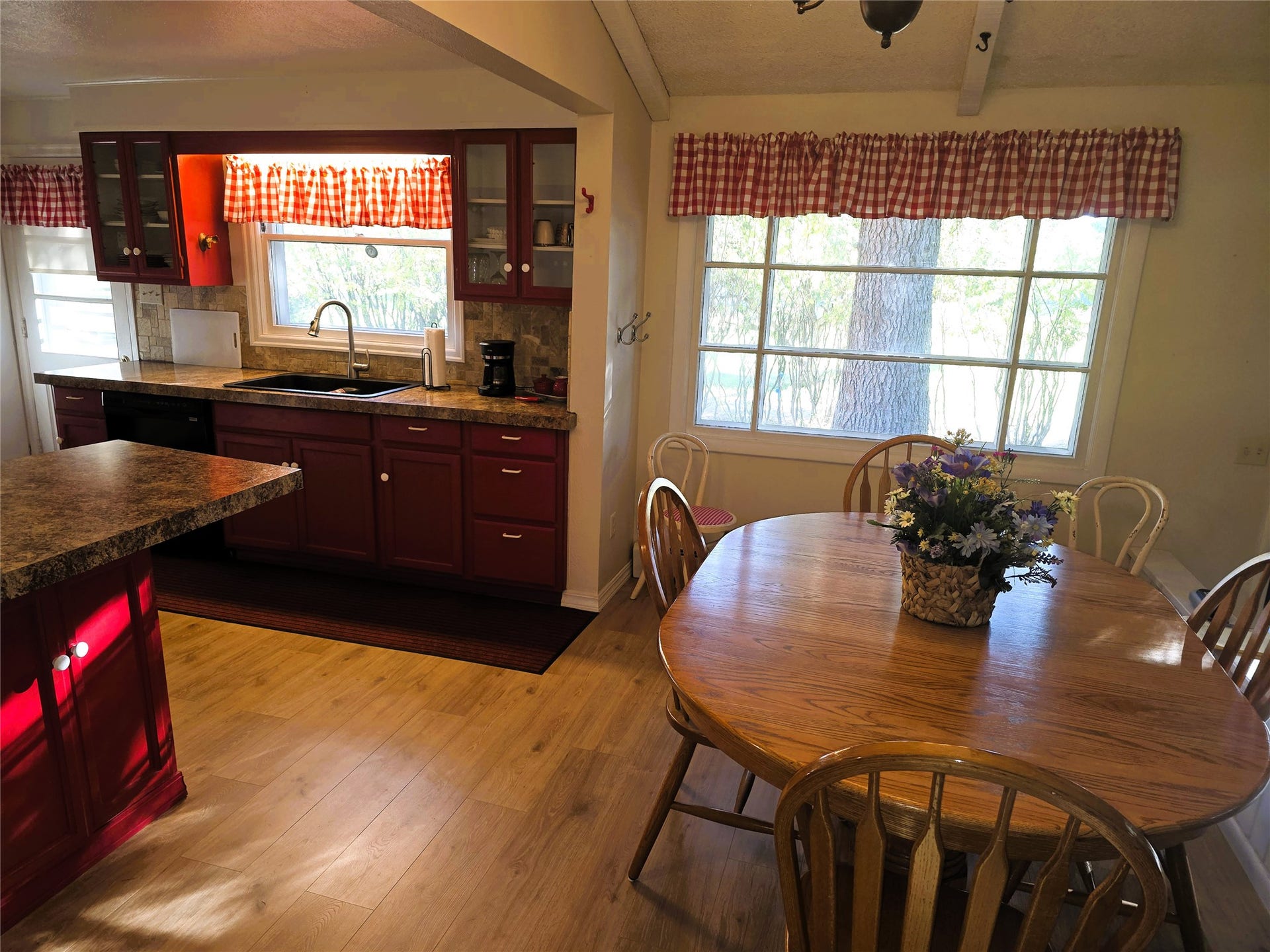 115 Ricketts Road, Hamilton, MT 59840 Kitchen featuring wood-finish flooring, dark red cabinetry, stone-look countertops, and a stainless steel faucet