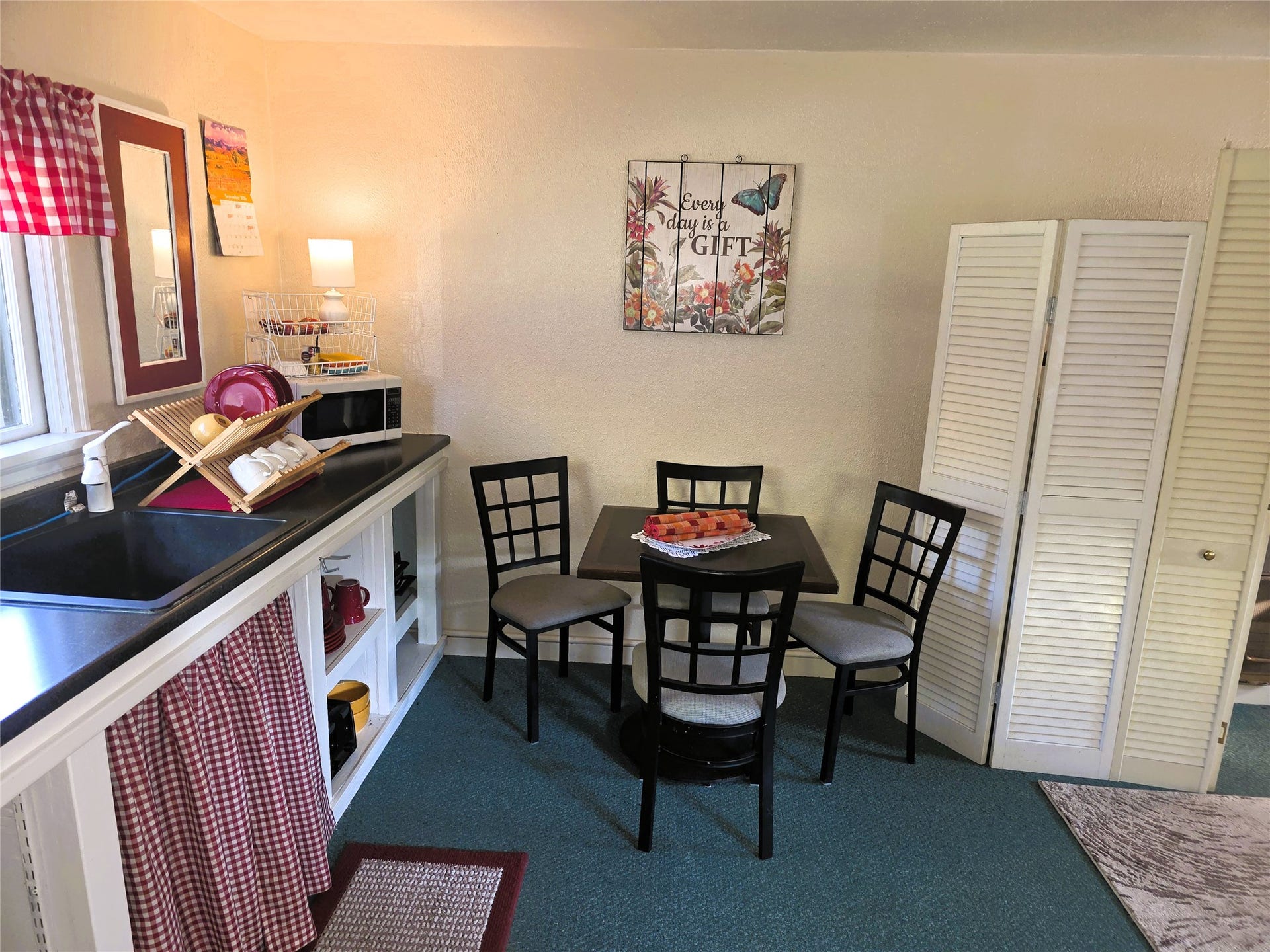 115 Ricketts Road, Hamilton, MT 59840 Kitchenette featuring a built-in sink, dark countertop, open shelving, and louvered bi-fold doors in guest house