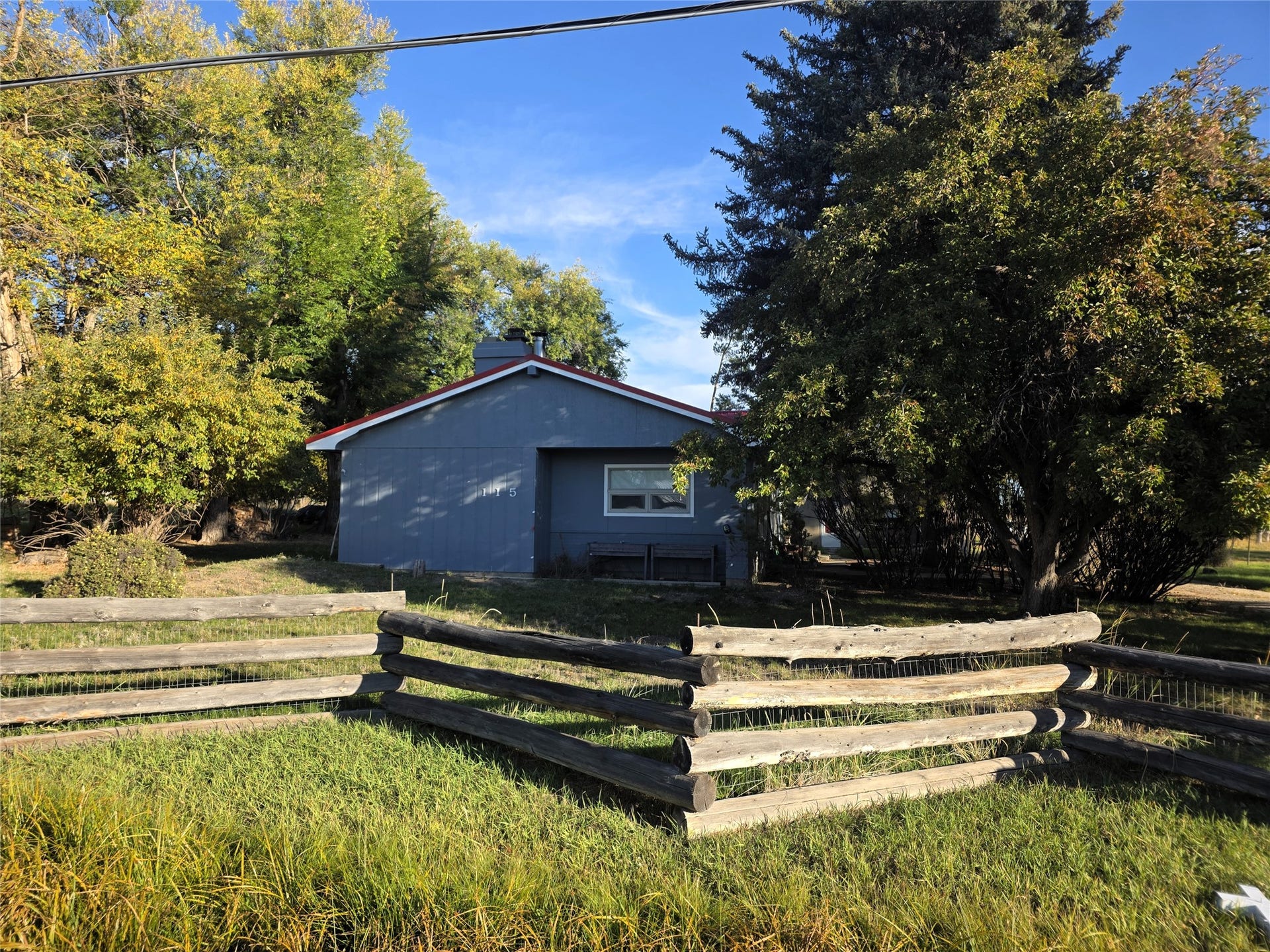115 Ricketts Road, Hamilton, MT 59840 Single-story residence with blue siding and a red roof, featuring a covered entry