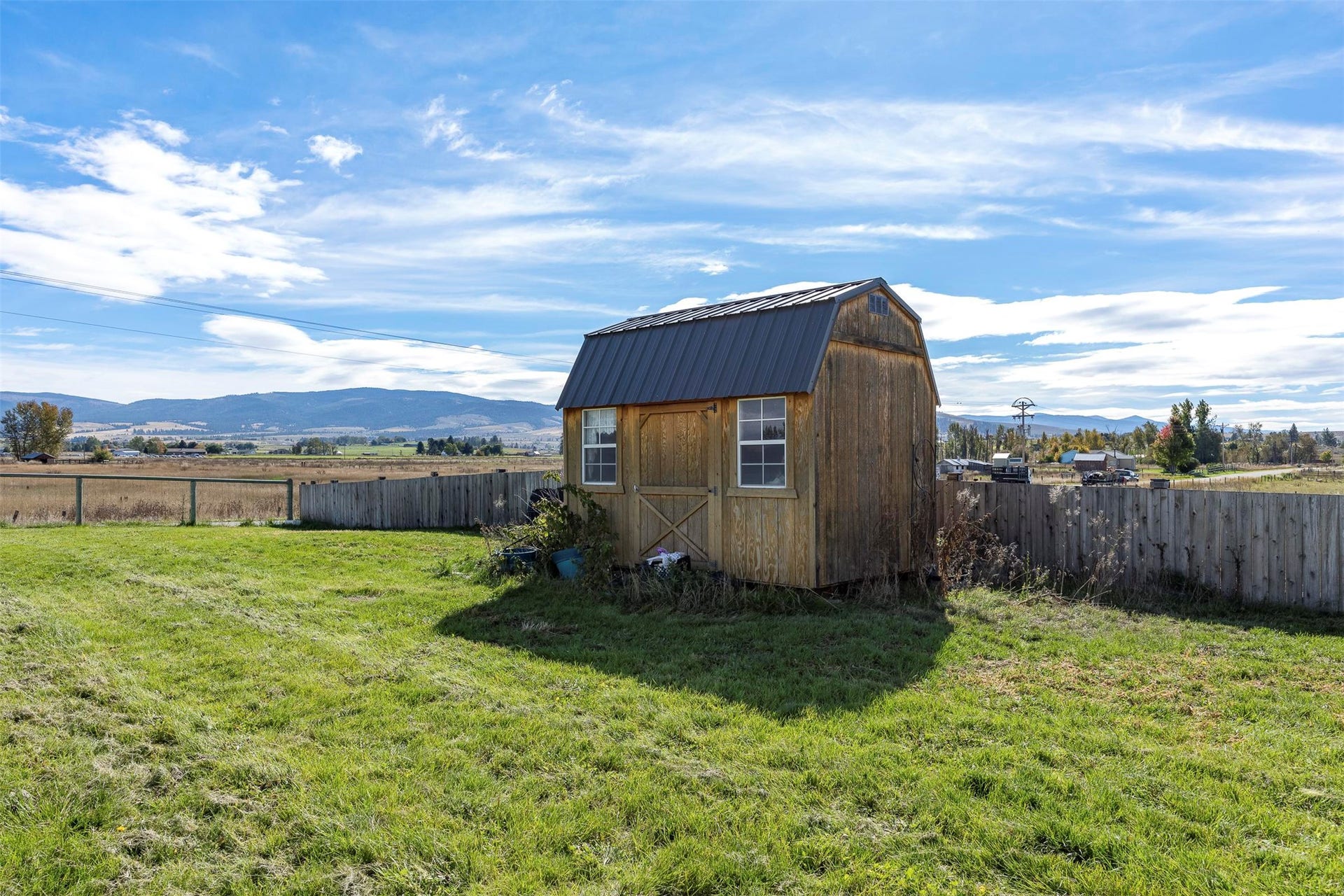 Wood-sided storage shed with a metal roof and two windows