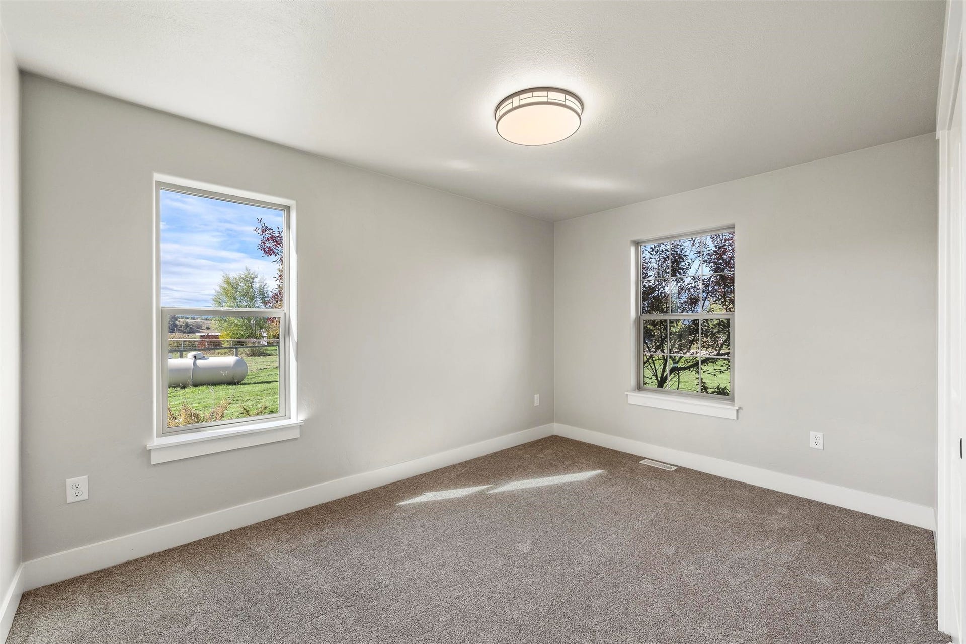 Neutral wall tones, recessed lighting fixture, carpeted flooring, and two windows