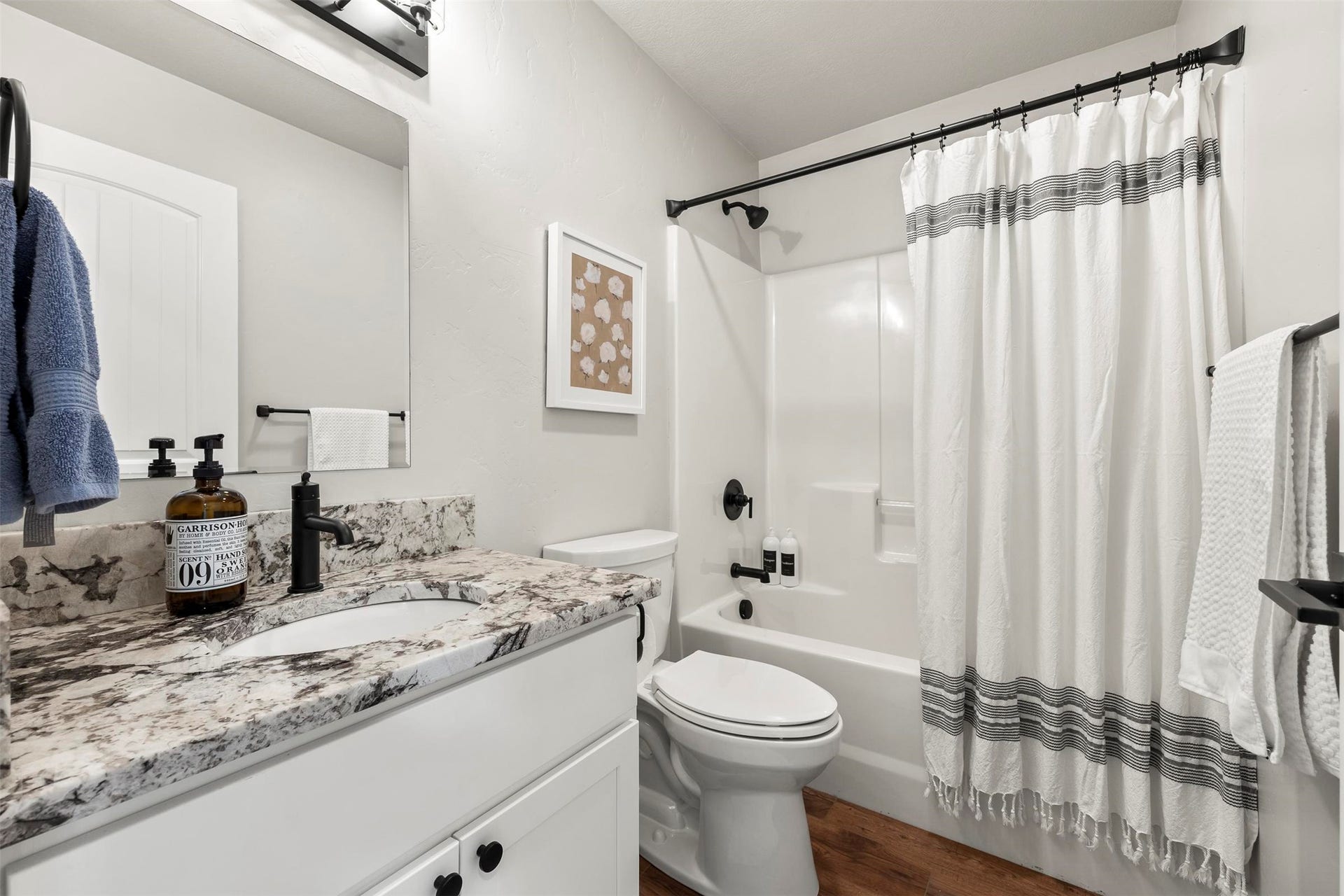 White vanity with a stone countertop and integrated sink