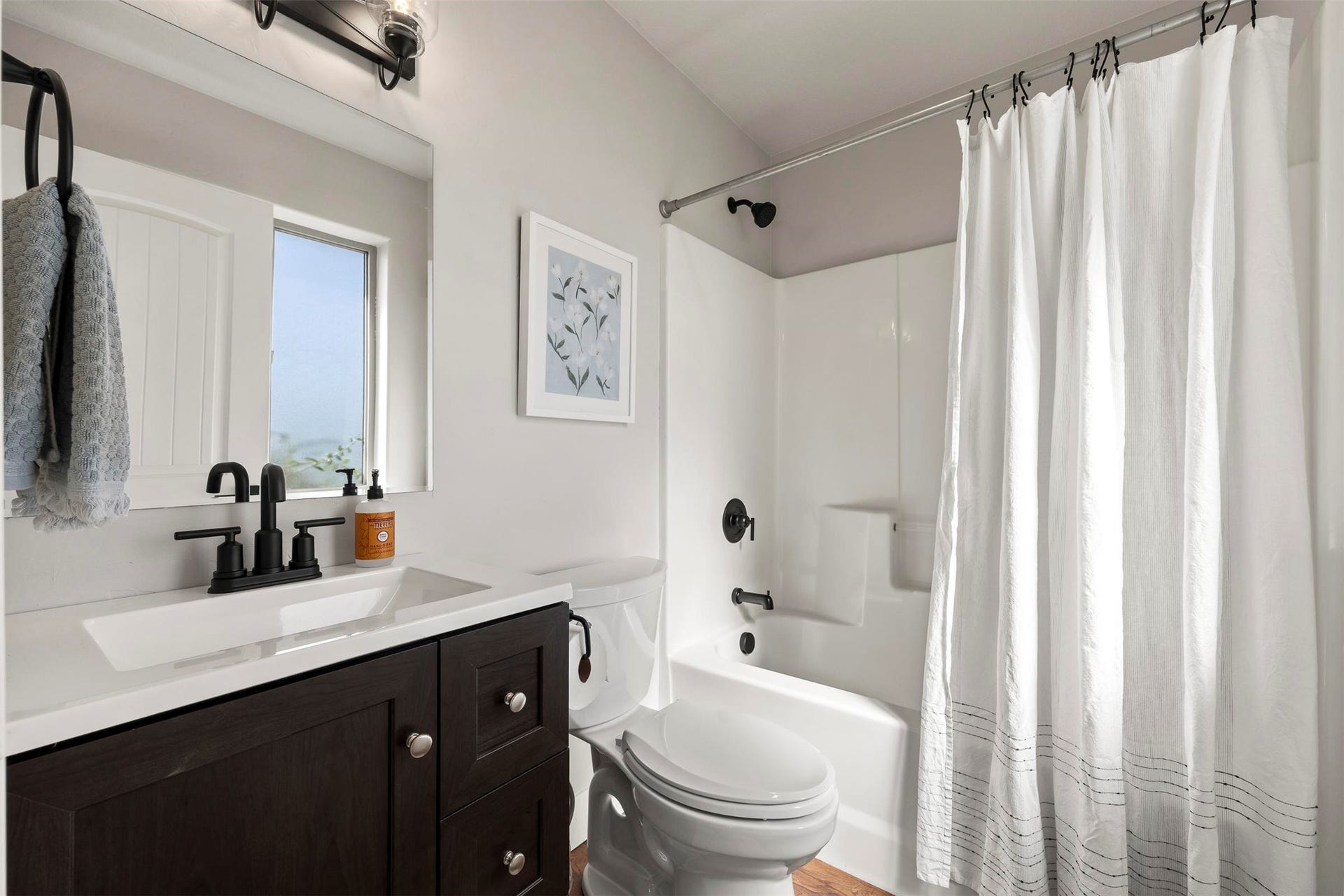 Dark wood-finish vanity with an integrated rectangular sink and matte black faucet
