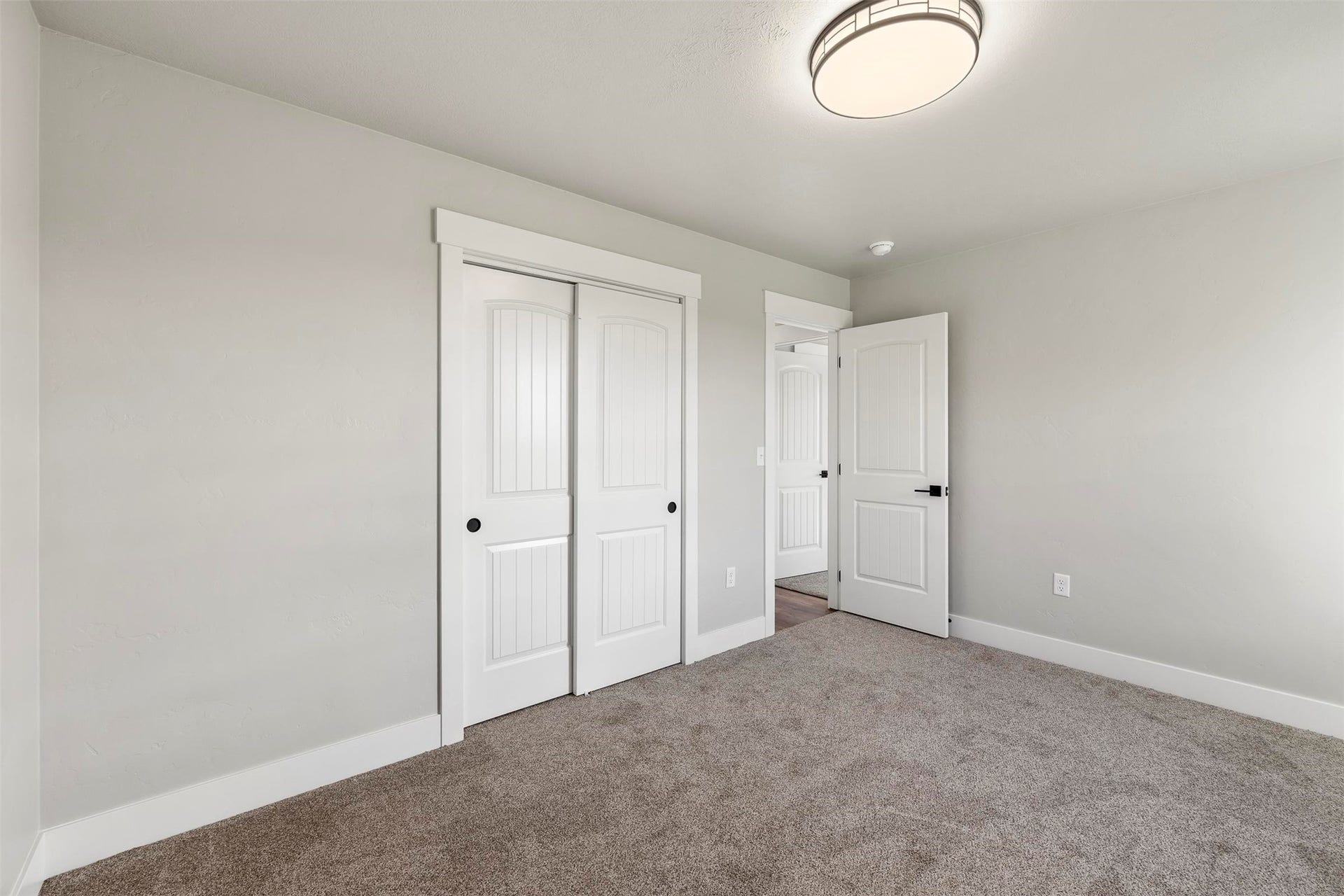Neutral color palette, white trim, recessed lighting fixture, carpeted flooring, and sliding panel closet doors