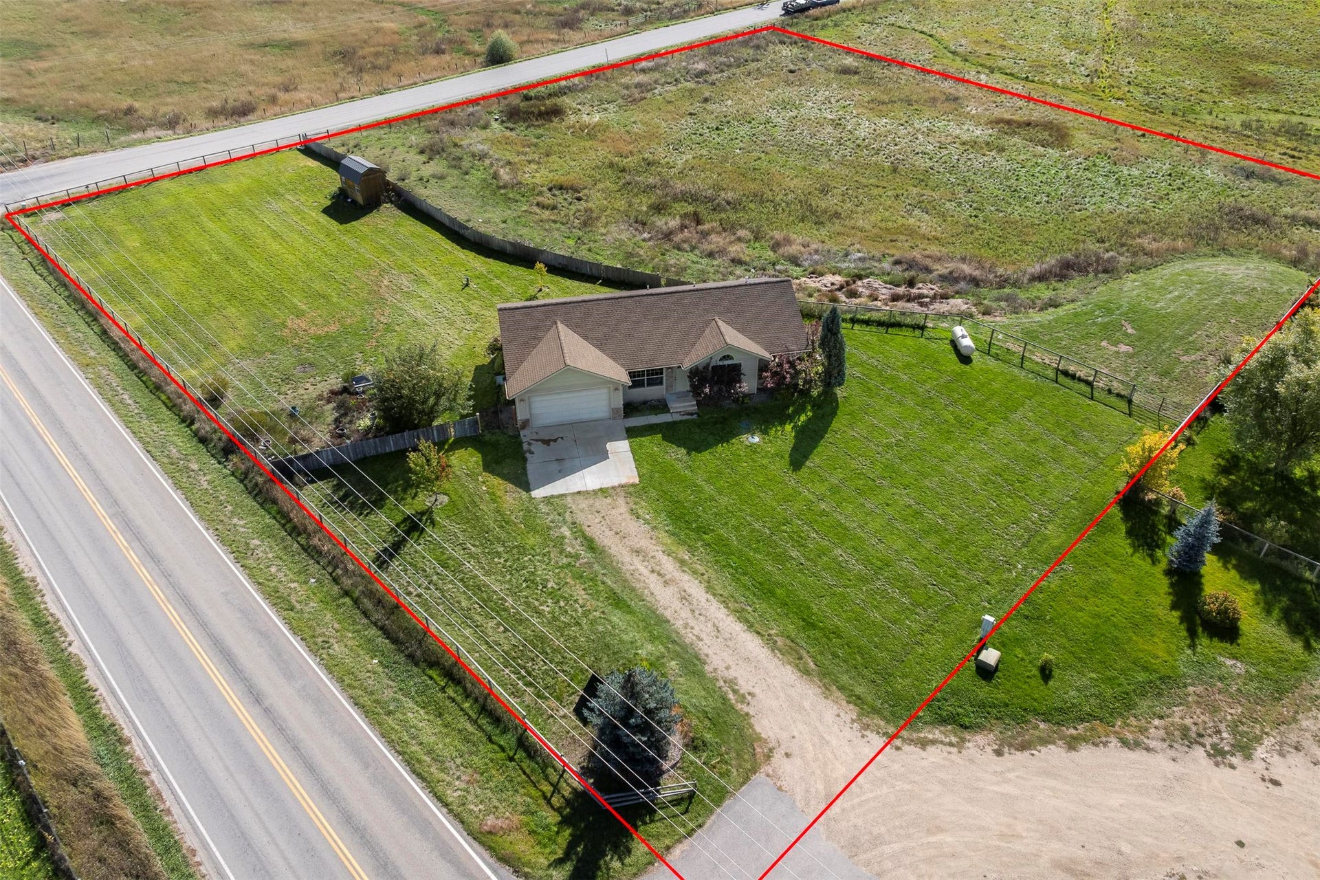 Single-story residence with an attached garage, paved driveway, and established lawn areas