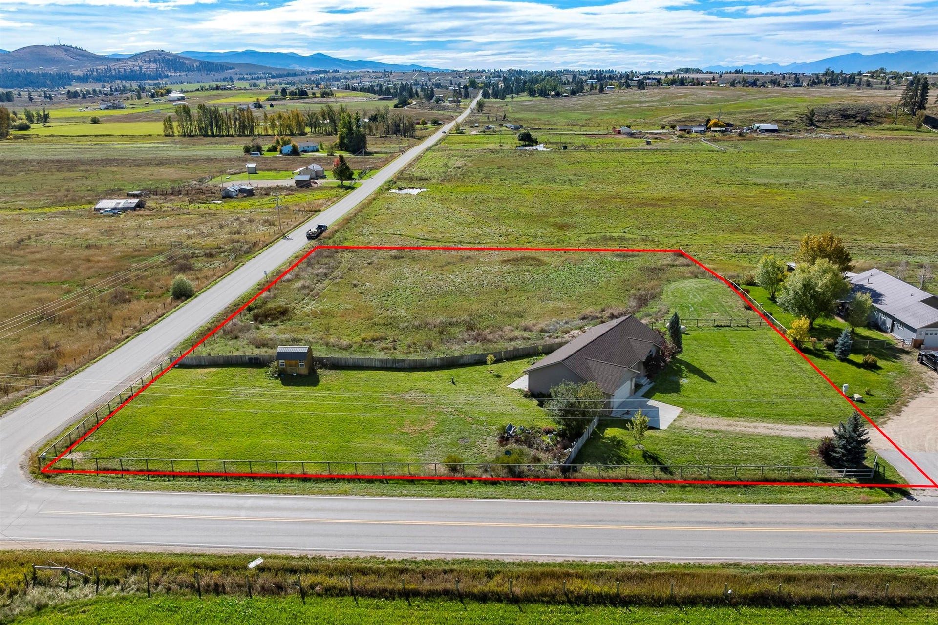 Expansive property featuring a single-story residence, a detached shed, and a paved driveway