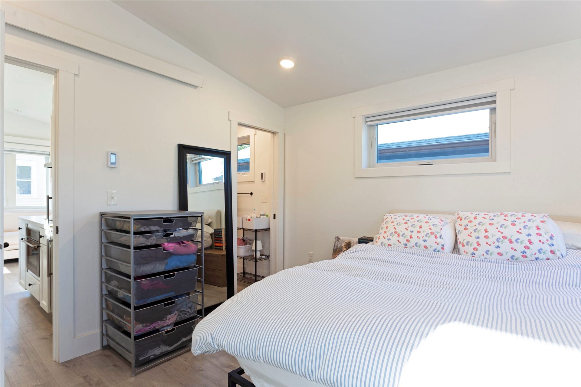 Recessed ceiling lighting, wood-finish flooring, and a horizontal window with white trim