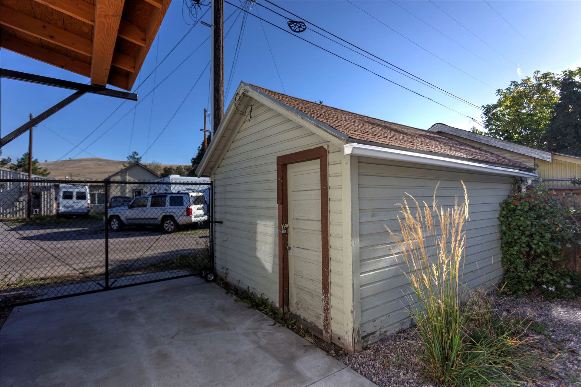 Detached outbuilding with horizontal siding and shingle roofing