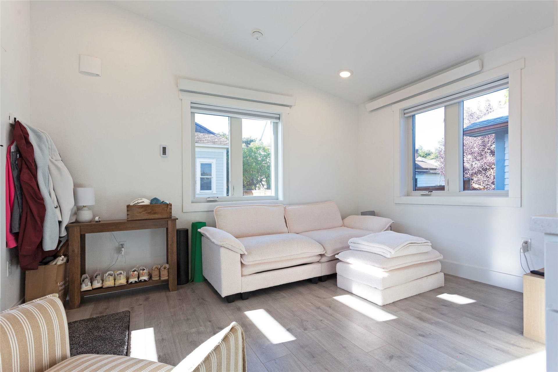 Wood-finish flooring, white walls, and multiple windows with white trim