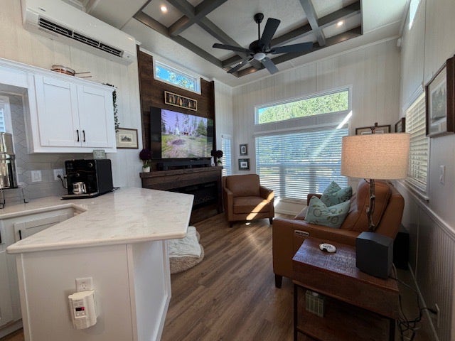 713 Shyrock Loop Dr., Superior, MT 59872 Wood-finish flooring, white paneling, coffered ceiling with recessed lighting, white kitchen cabinetry with a marbled countertop, and horizontal windows with blinds