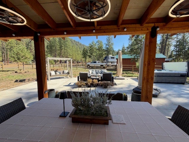 713 Shyrock Loop Dr., Superior, MT 59872 Covered patio area with wood beam construction, contemporary ceiling light fixtures, and a patio set
