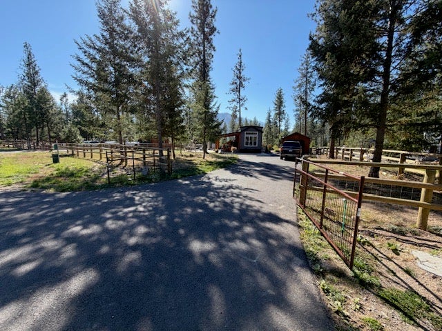 713 Shyrock Loop Dr., Superior, MT 59872 Paved driveway leading to a fenced property with mature trees