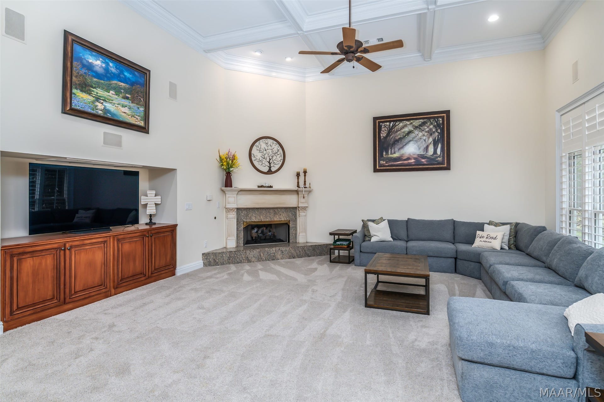 Impressive great room with soaring ceilings, detailed millwork, fireplace, built-in entertainment cabinetry and abundant space for comfortable gathering.