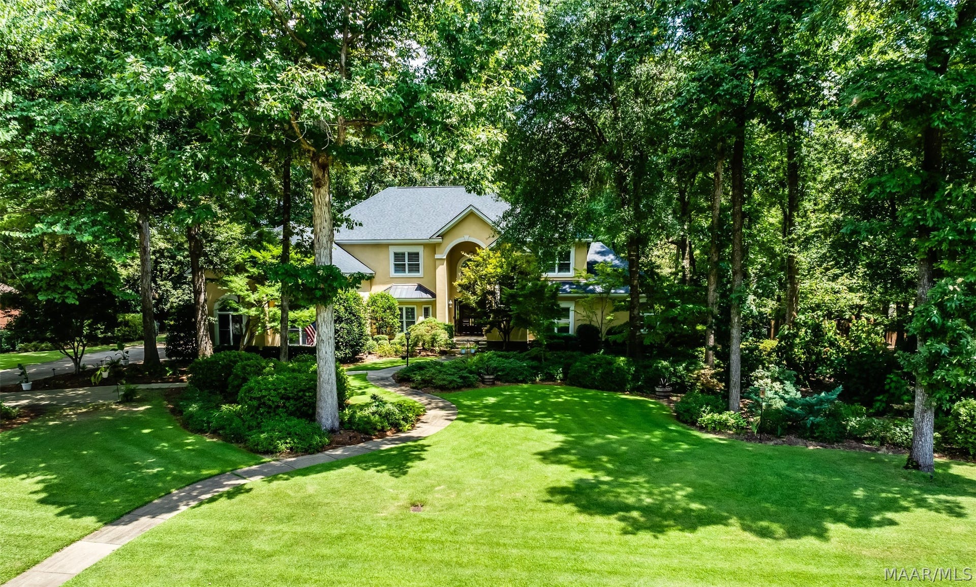 Beautifully landscaped grounds and towering mature trees frame the home, creating an impressive sense of privacy and a gracious approach to the residence.