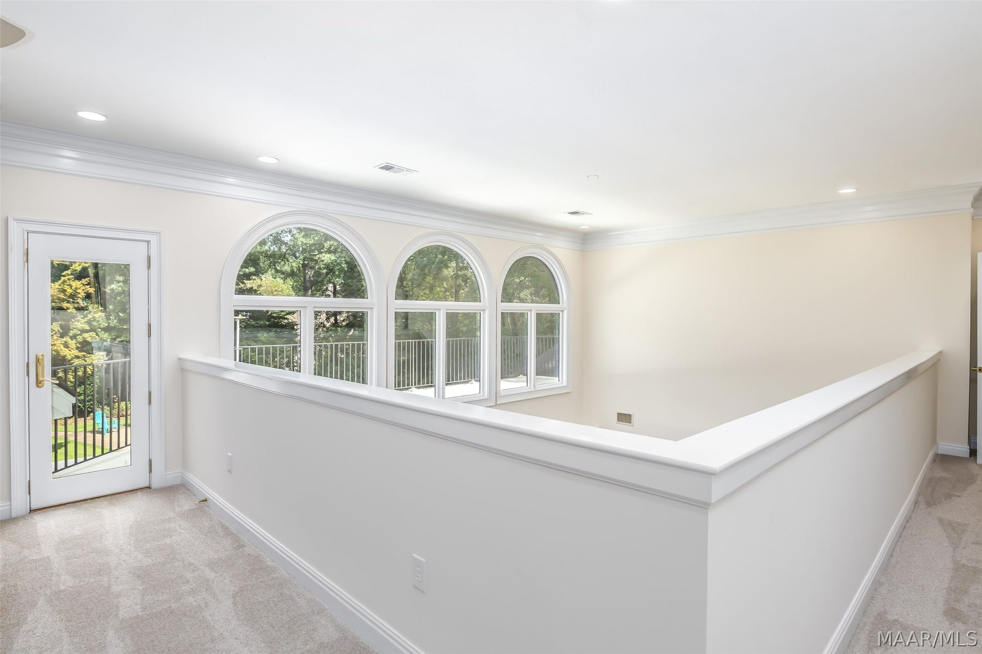Bright, open upper-level landing features beautiful arched windows, extensive natural light and direct access to the outdoor terrace.