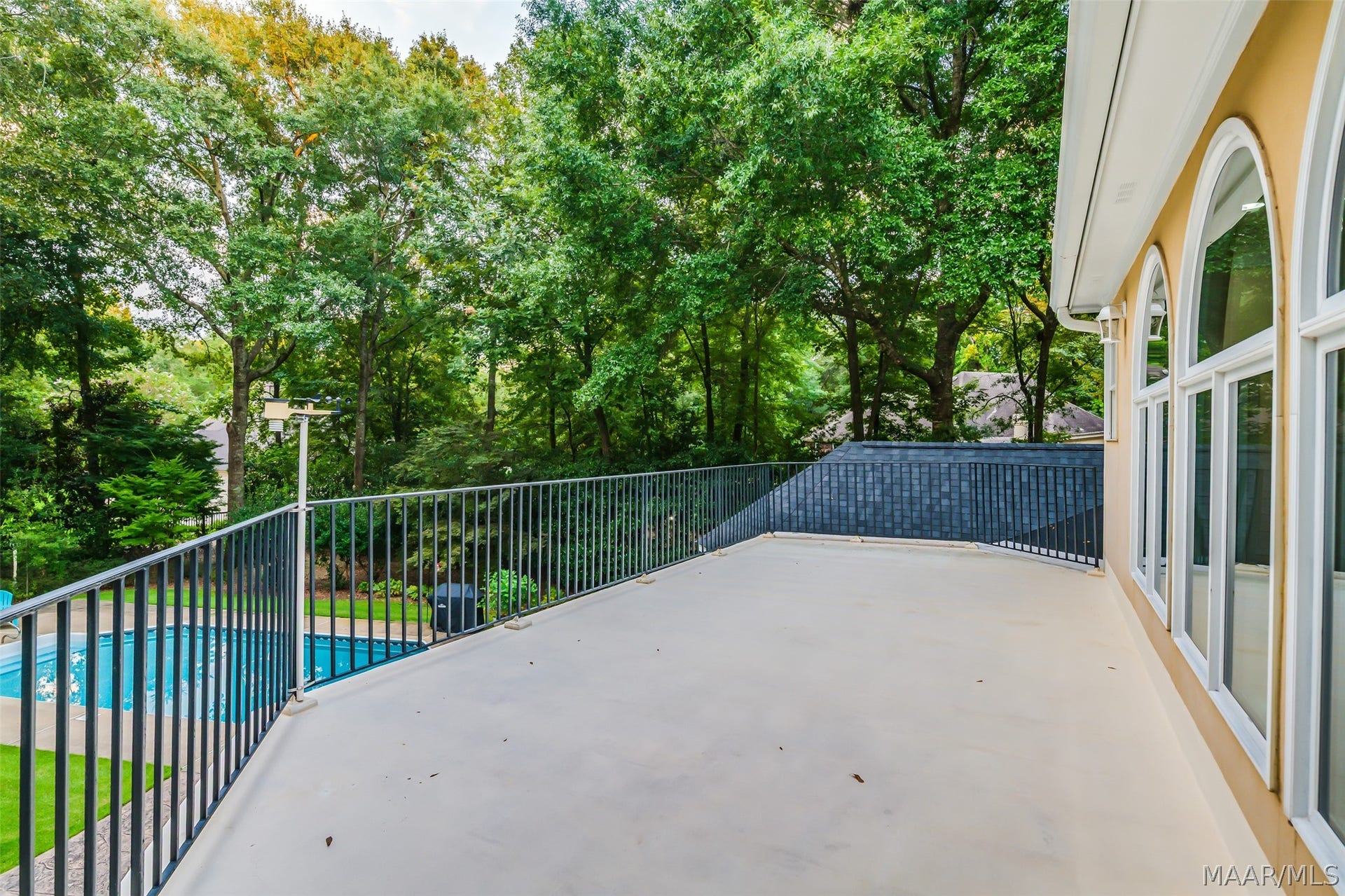 Private terrace overlooks the pool & tree-filled backyard, providing a peaceful setting for relaxing or entertaining.