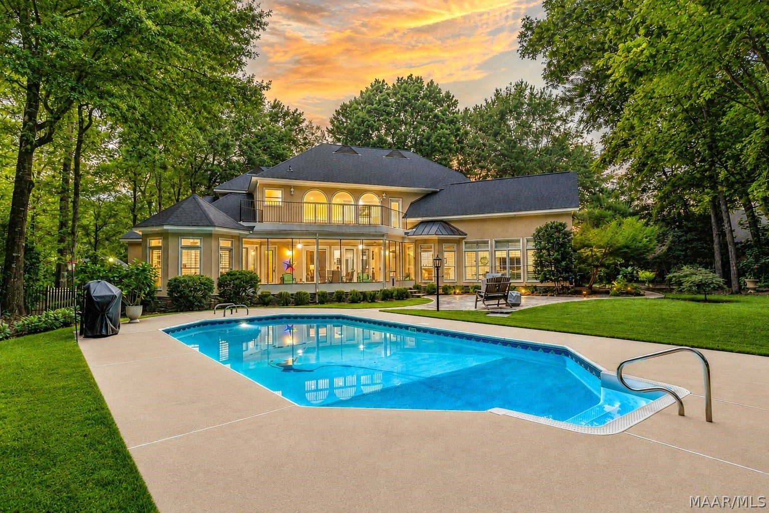 Private backyard retreat featuring an in-ground pool, expansive lawn, mature landscaping and a spacious screened porch overlooking it all.