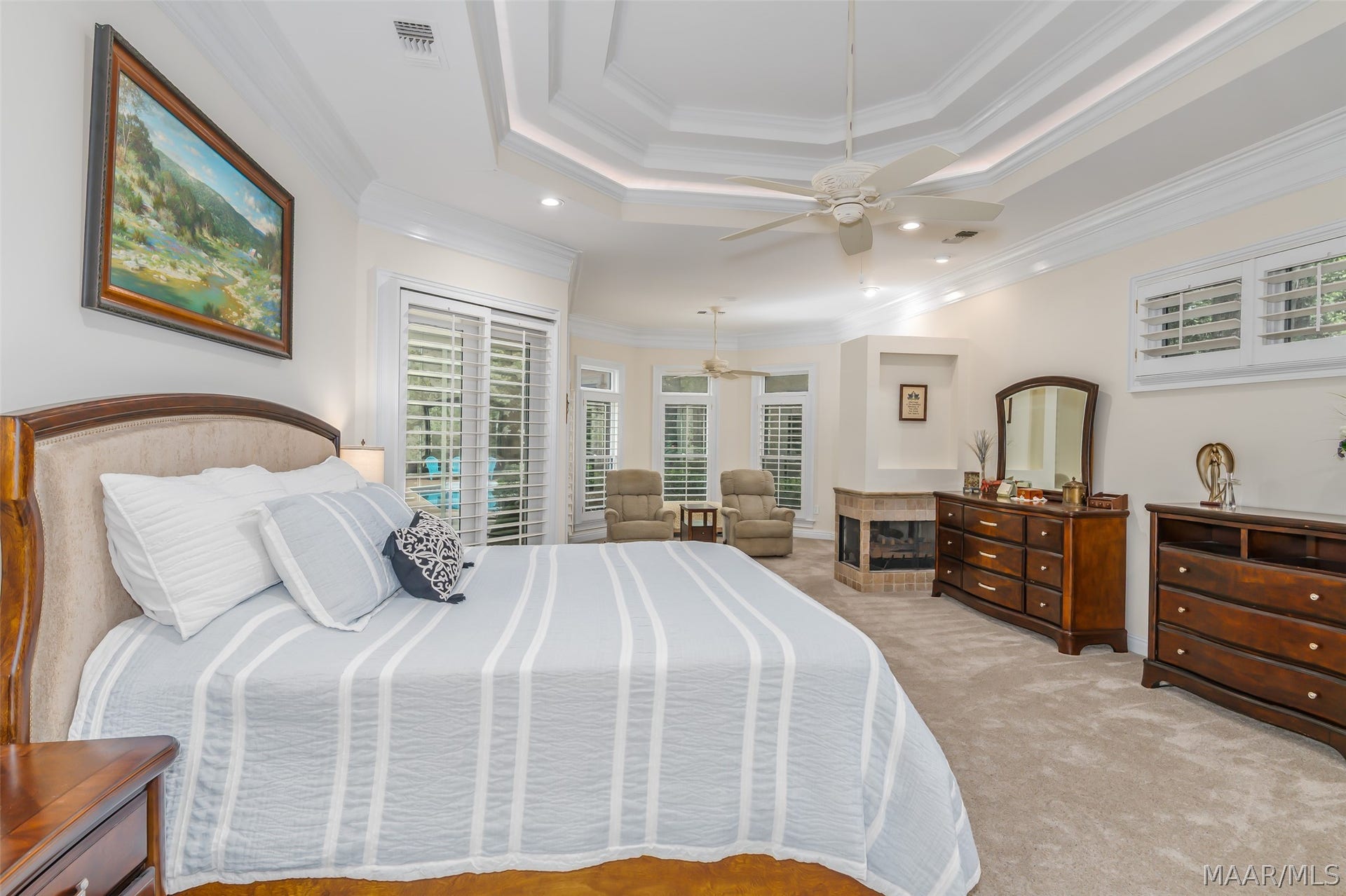 A spacious owners suite offers a relaxing retreat with a dramatic tray ceiling, cozy fireside sitting area.