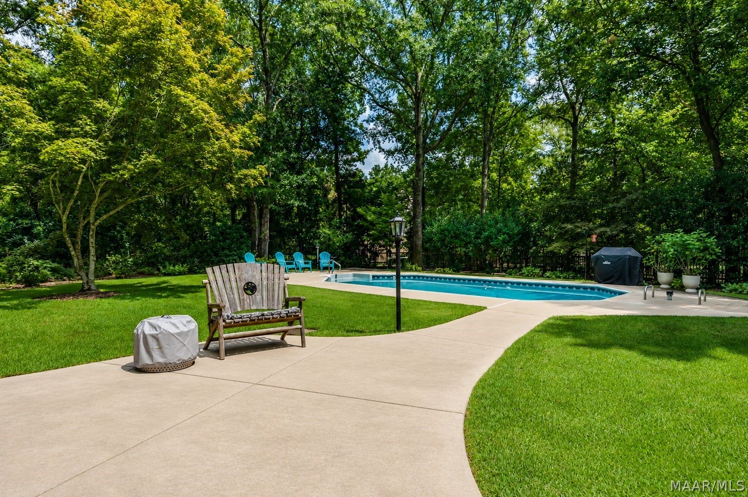 Back patio flows effortlessly to the pool and manicured grounds, offering an exceptional setting for outdoor living and entertaining.
