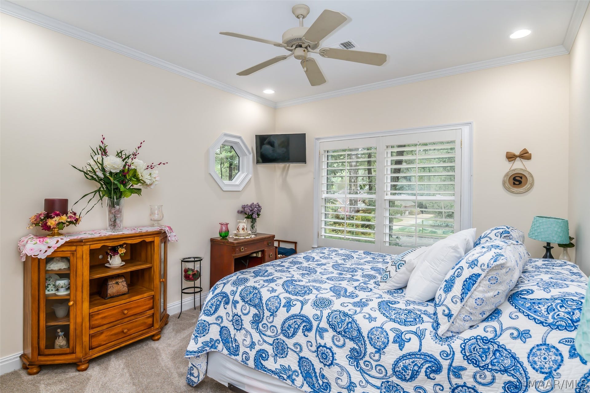 Bright, comfortable guest bedroom with generous proportions, plantation shutters and peaceful views of the surrounding greenery.