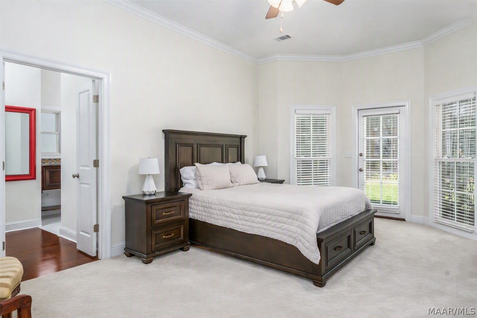 Downstairs primary bedroom offers a sitting area & doors to  lovely backyard.