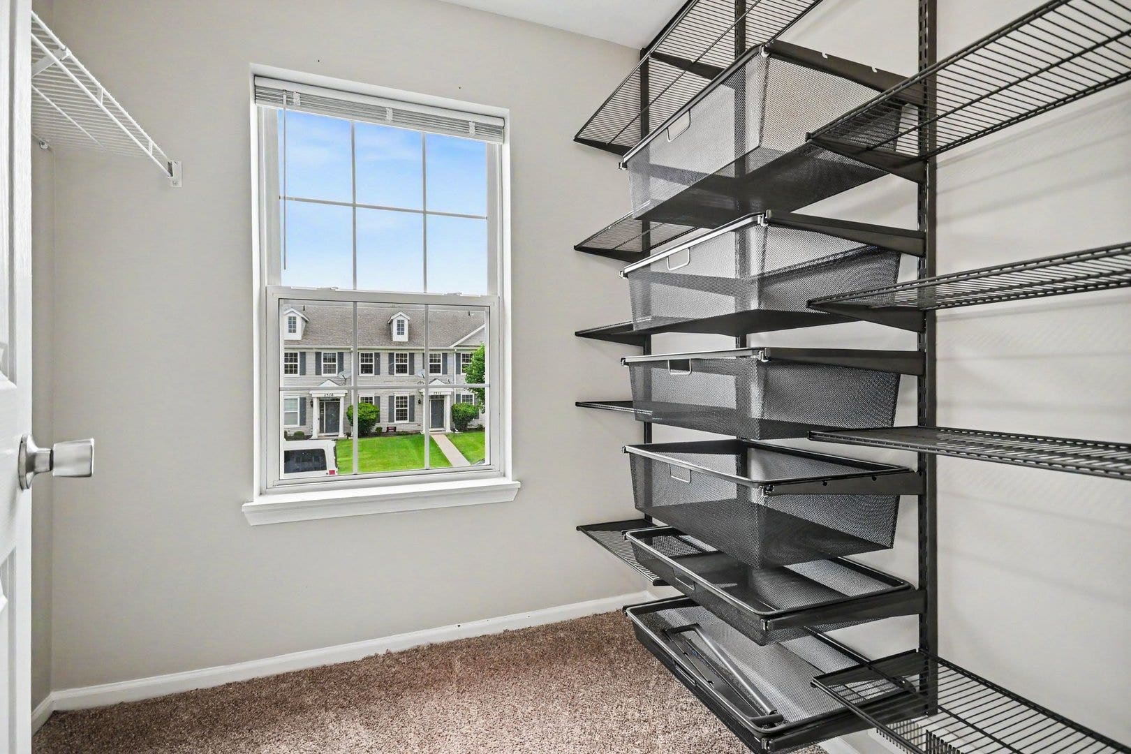 Spacious primary suite walk-in closet featuring a