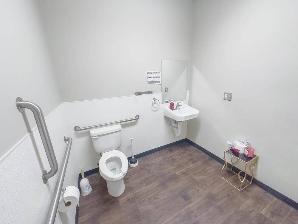 142 Paul Bunyan Drive NW, Bemidji, MN 56601 Spacious bathroom with accessibility features including multiple grab bars and open floor area. Durable flooring and light wall tones create a bright, practical environment.
