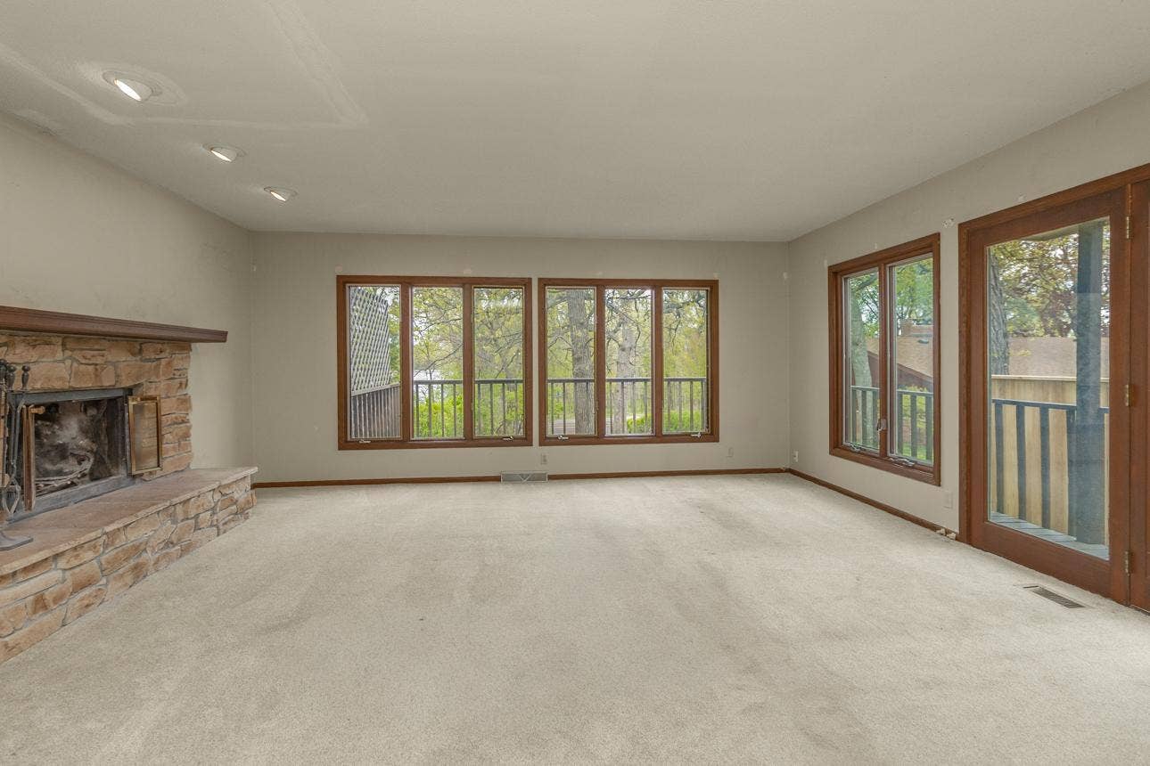 Living room features woodburning fireplace and lake views.