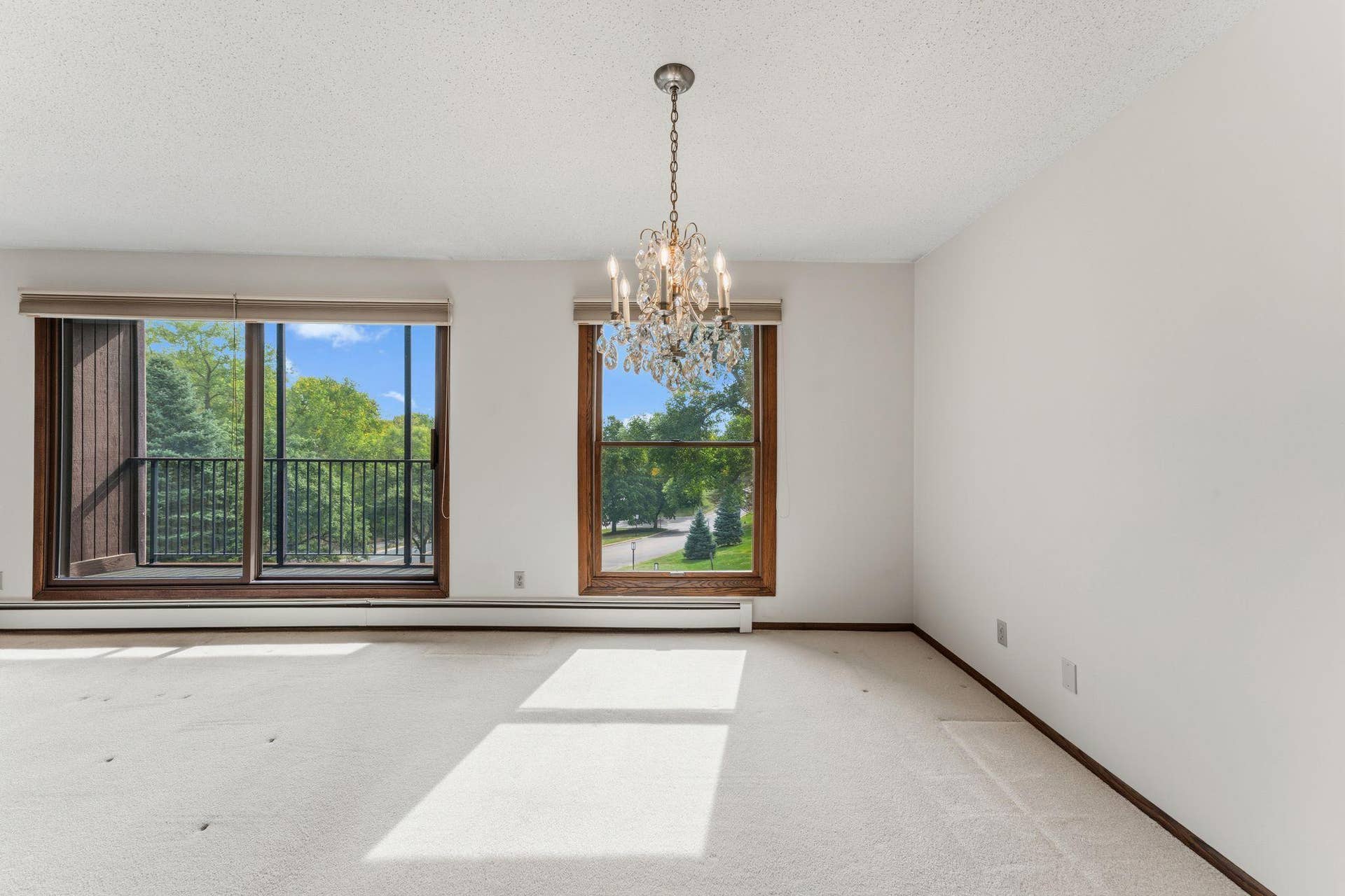 The dining room features a large window and chandelier