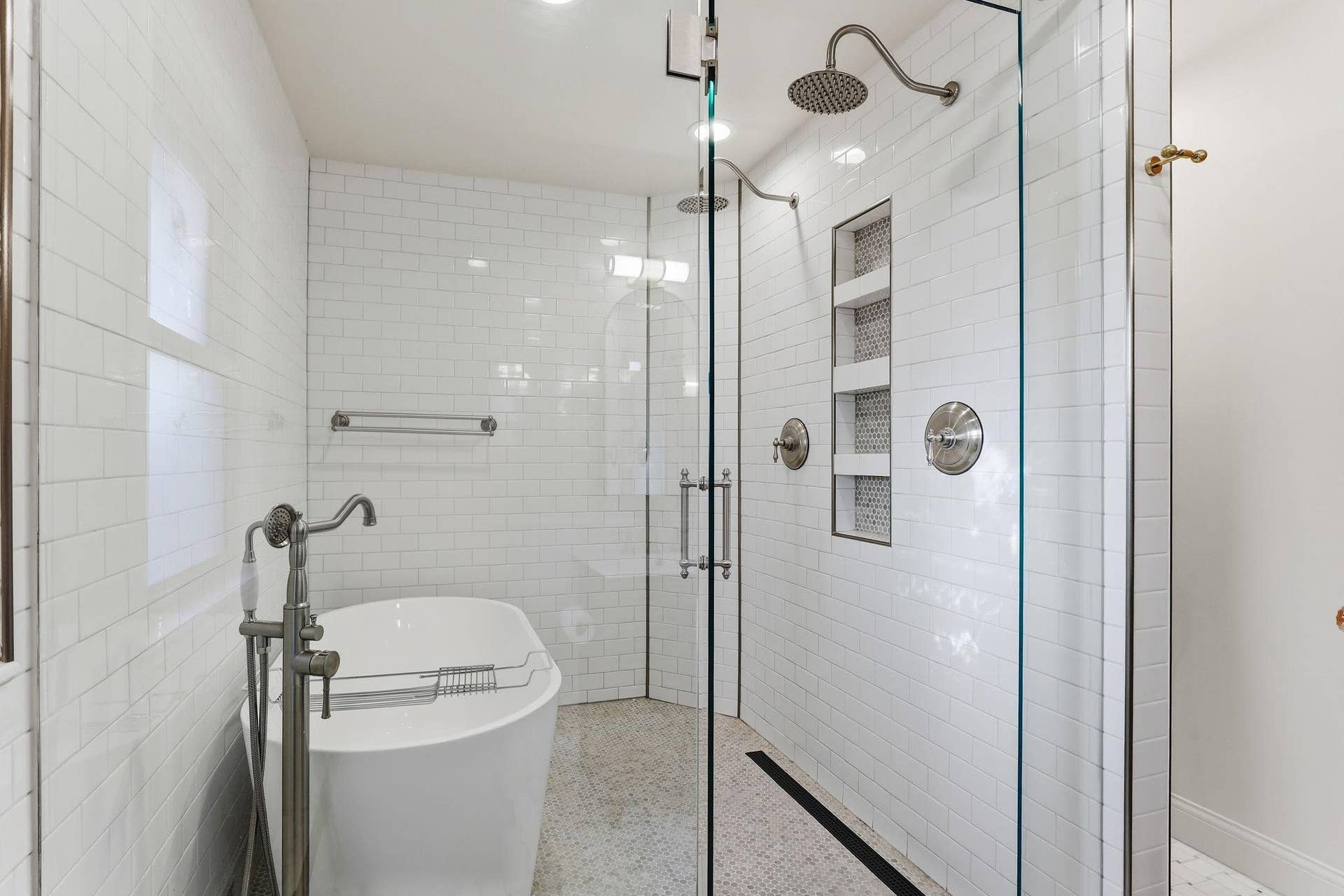 1707 Eugene Street, White Bear Lake, MN 55110 Inside the wet room, dual rain shower heads and a tiled storage niche surround the freestanding tub.