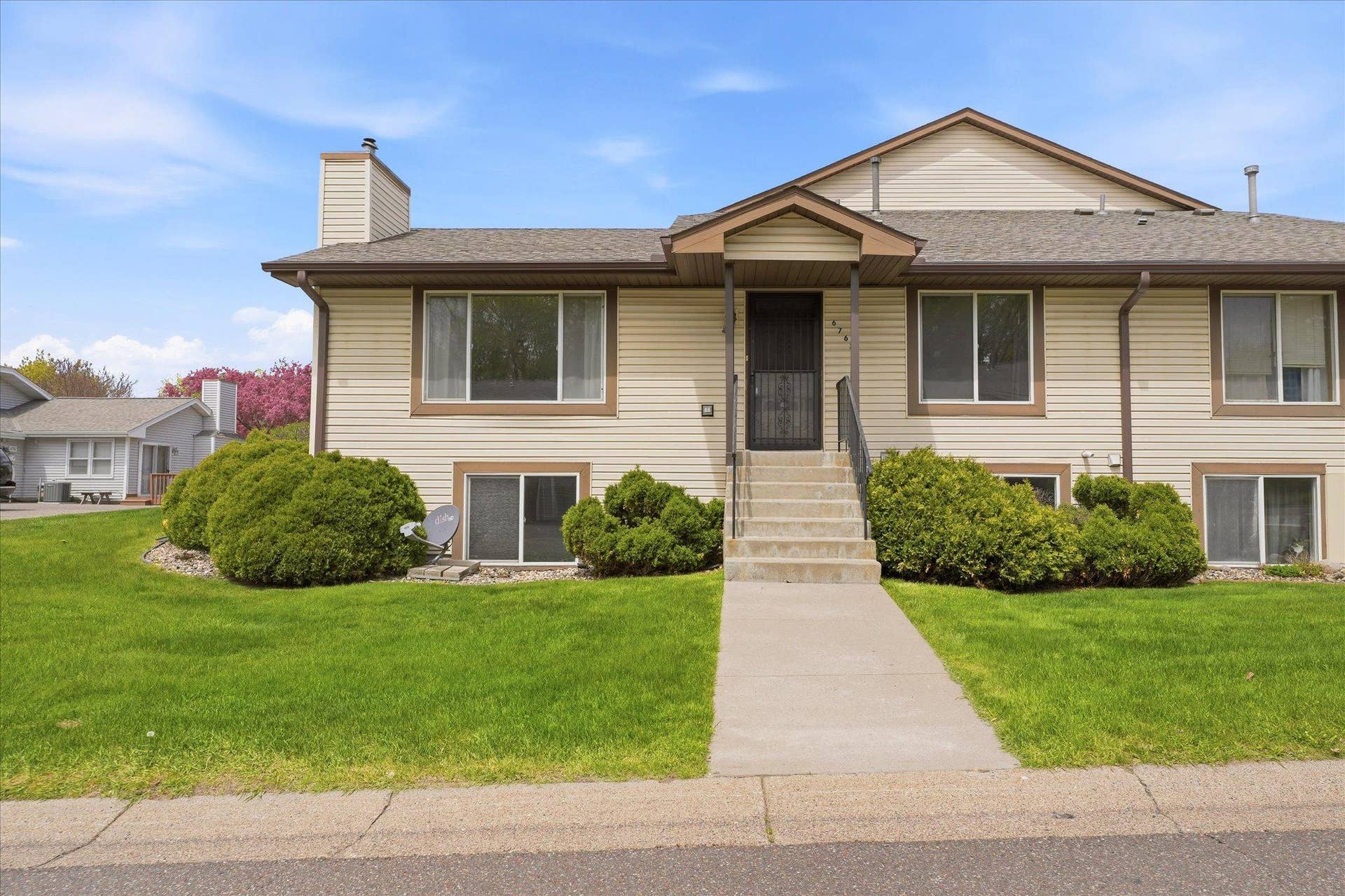 6762 Gretchen Court N, Oakdale, MN 55128 Charming end-unit townhome with mature landscaping, great curb appeal, and a welcoming front entrance.