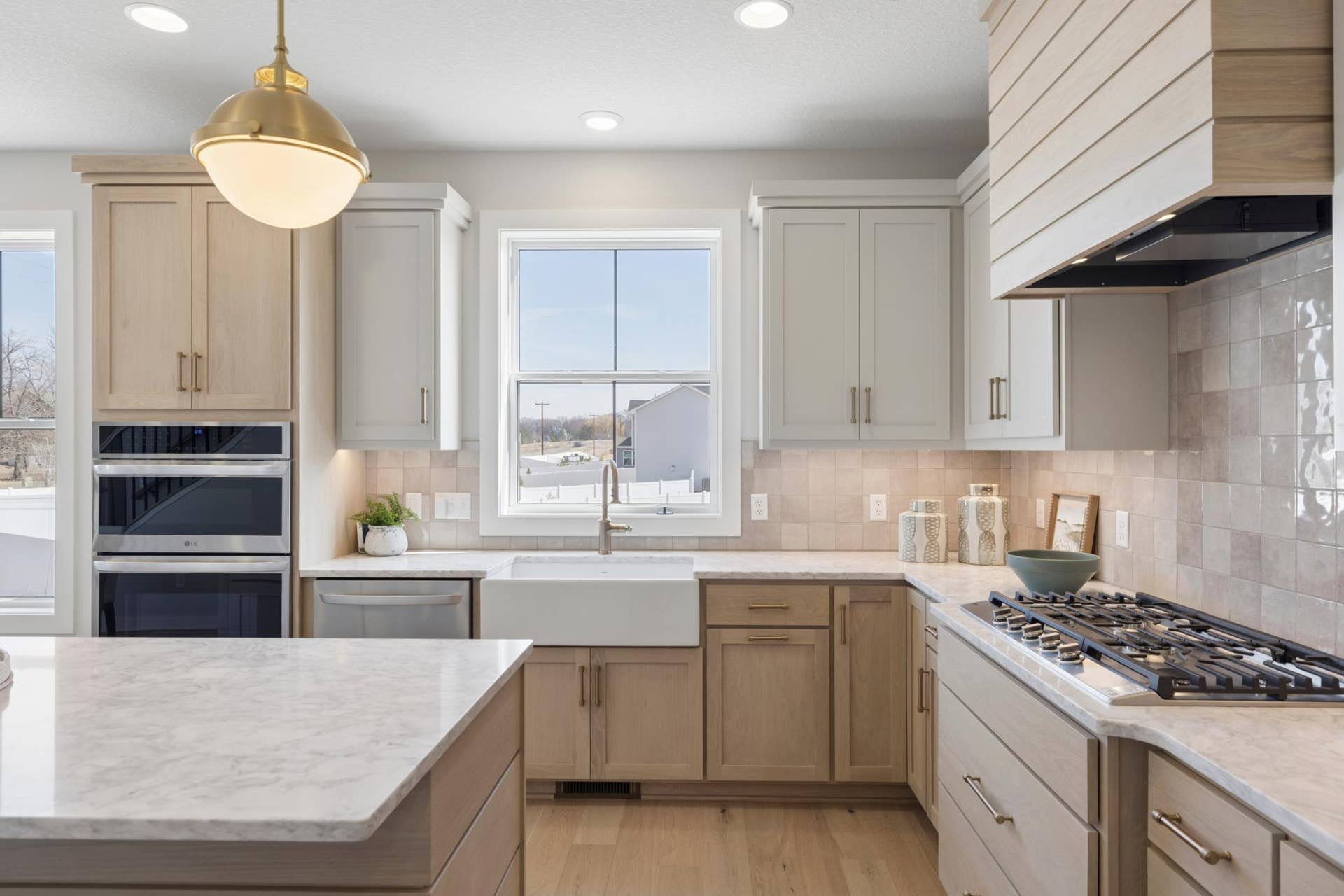 5003 Airlake Drive, Woodbury, MN 55129 Gas cooktop with vented hood and ceramic tile backsplash.