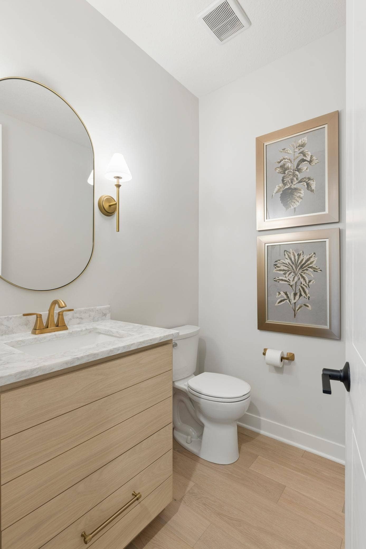 5003 Airlake Drive, Woodbury, MN 55129 Powder room features custom white oak vanity with quartz countertops along with beautiful framed mirror.