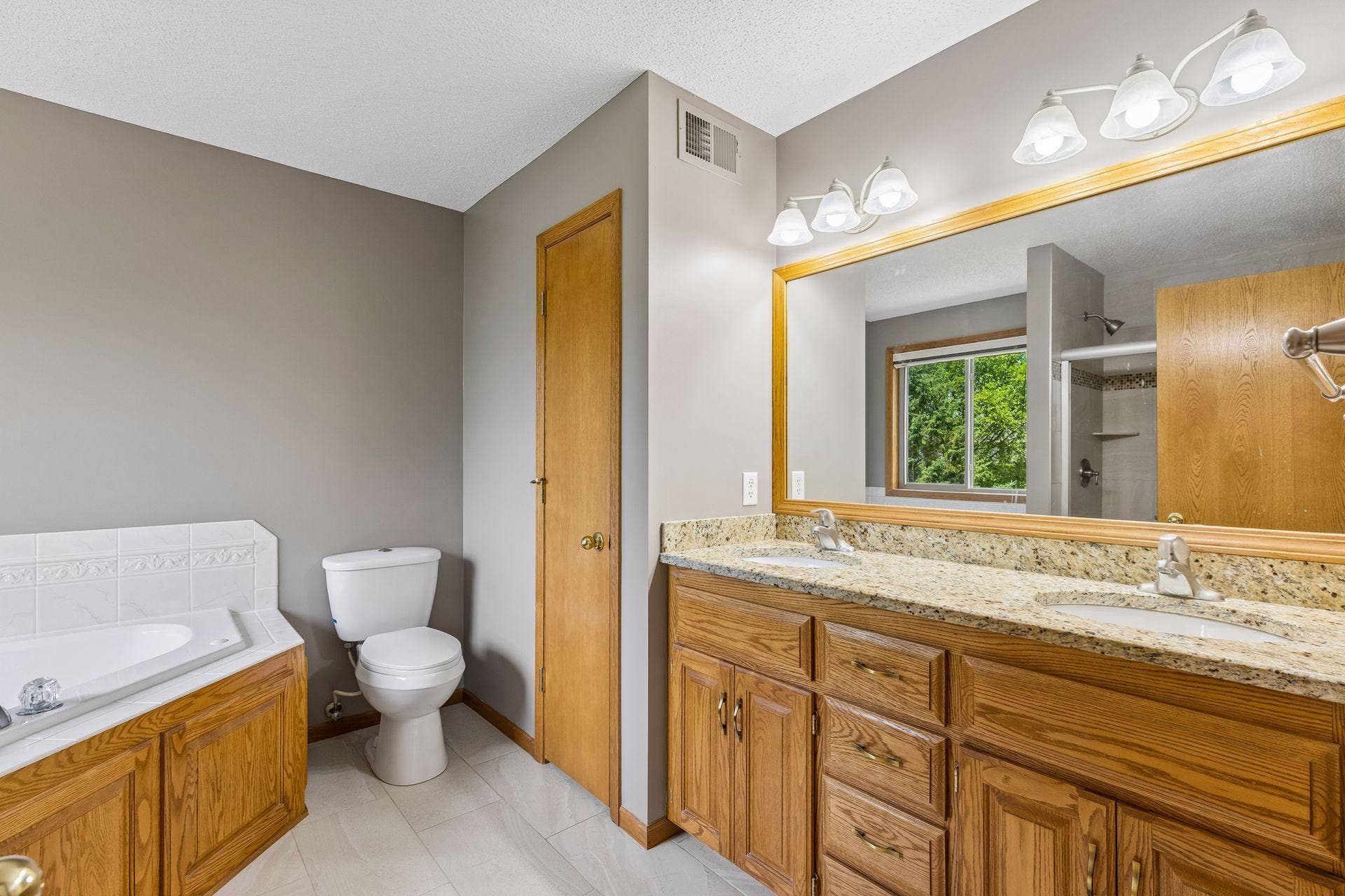 ENSUITE BATH WITH DUAL SINKS, GRANTE, AND SPA TUB