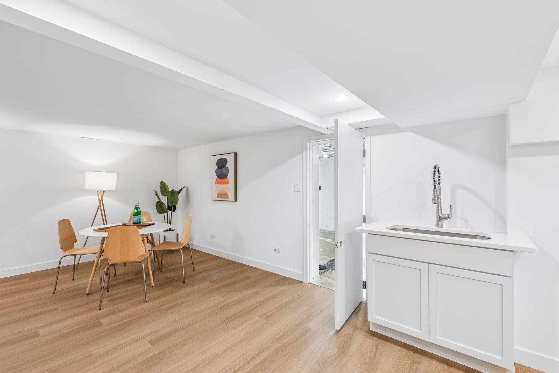 34x14 Lower level Family room with East-facing updated glass block windows, new paint, new luxury vinyl flooring, and lighting.  New Sink for possible second kitchen or Bar.
