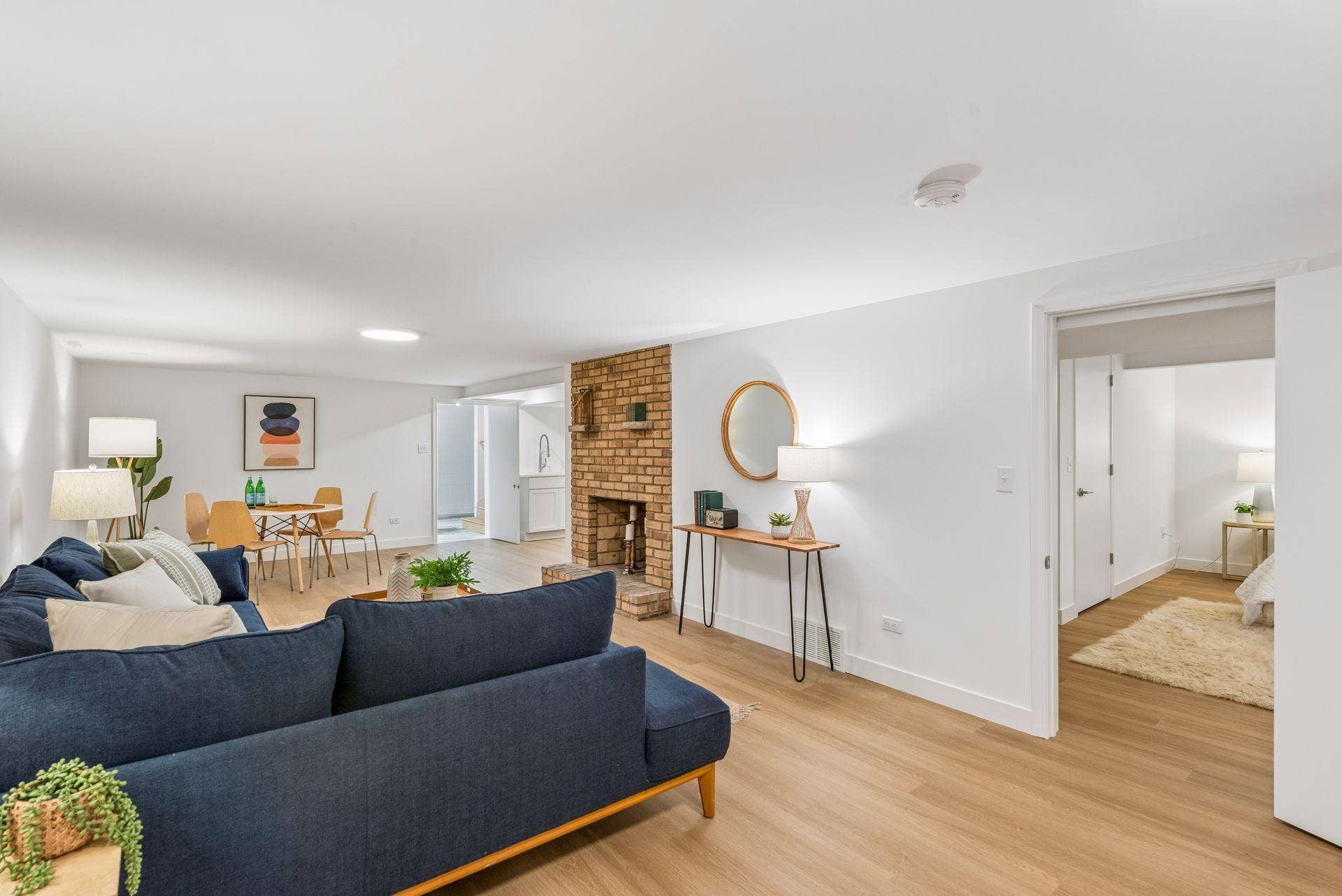 34x14 Lower level Family room with East-facing updated glass block windows, new paint, new luxury vinyl flooring, and lighting.