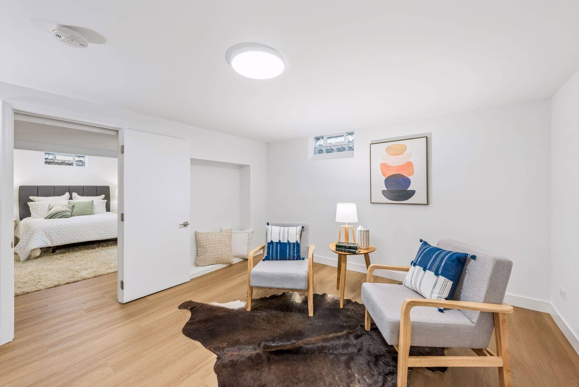 34x14 Lower level Family room with East-facing updated glass block windows, new paint, new luxury vinyl flooring, and lighting.