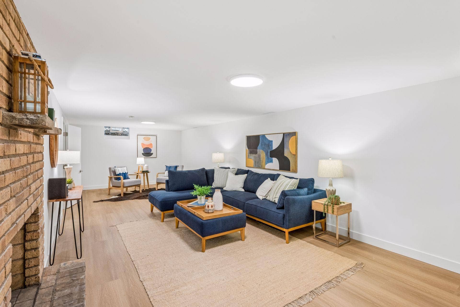 34x14 Lower level Family room with East-facing updated glass block windows, new paint, new luxury vinyl flooring, and lighting.