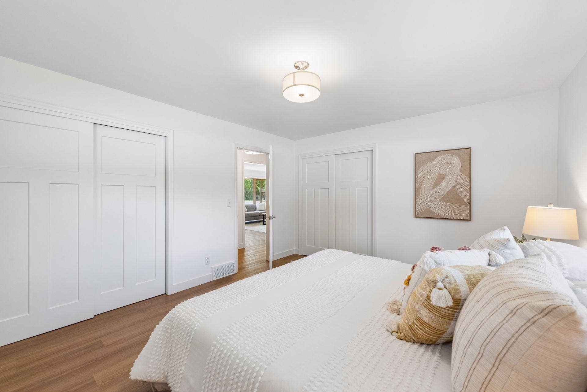 14x12 Main floor Bedroom #1 with East and north-facing updated windows, new paint, New trim and closet doors, new luxury vinyl flooring, and lighting.