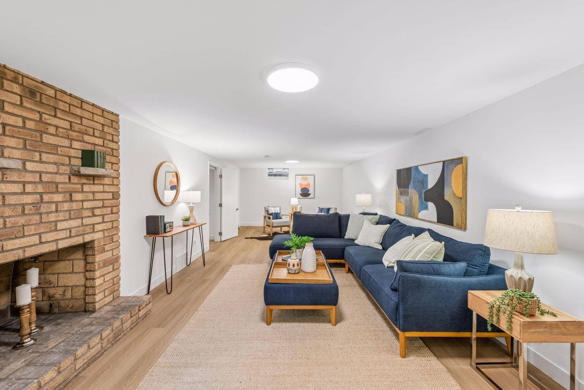 34x14 Lower level Family room with East-facing updated glass block windows, new paint, new luxury vinyl flooring, and lighting.