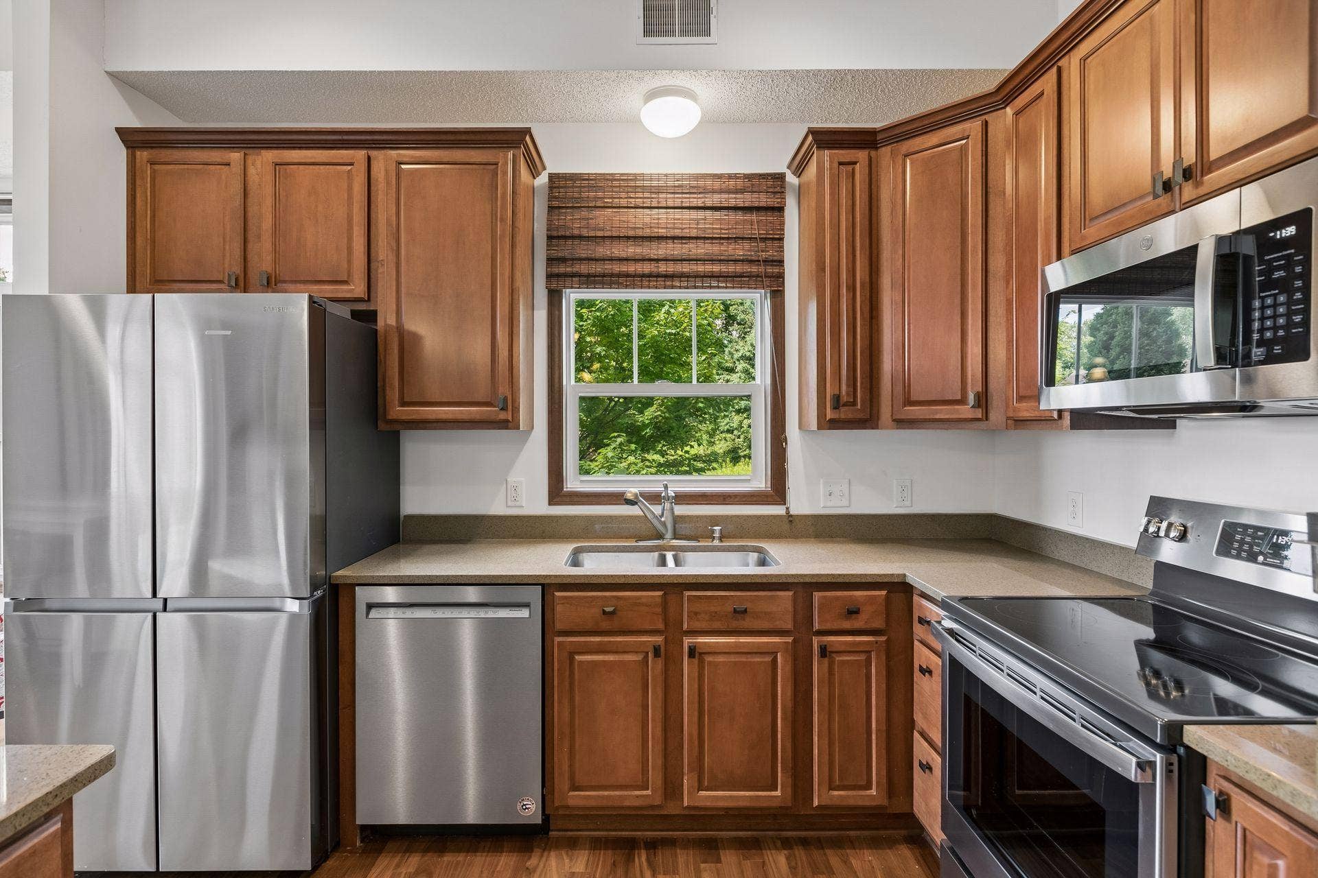 A charming kitchen window fills the space with natural light, complementing updated appliances, generous work surfaces, and a layout designed for both everyday living and effortless entertaining.