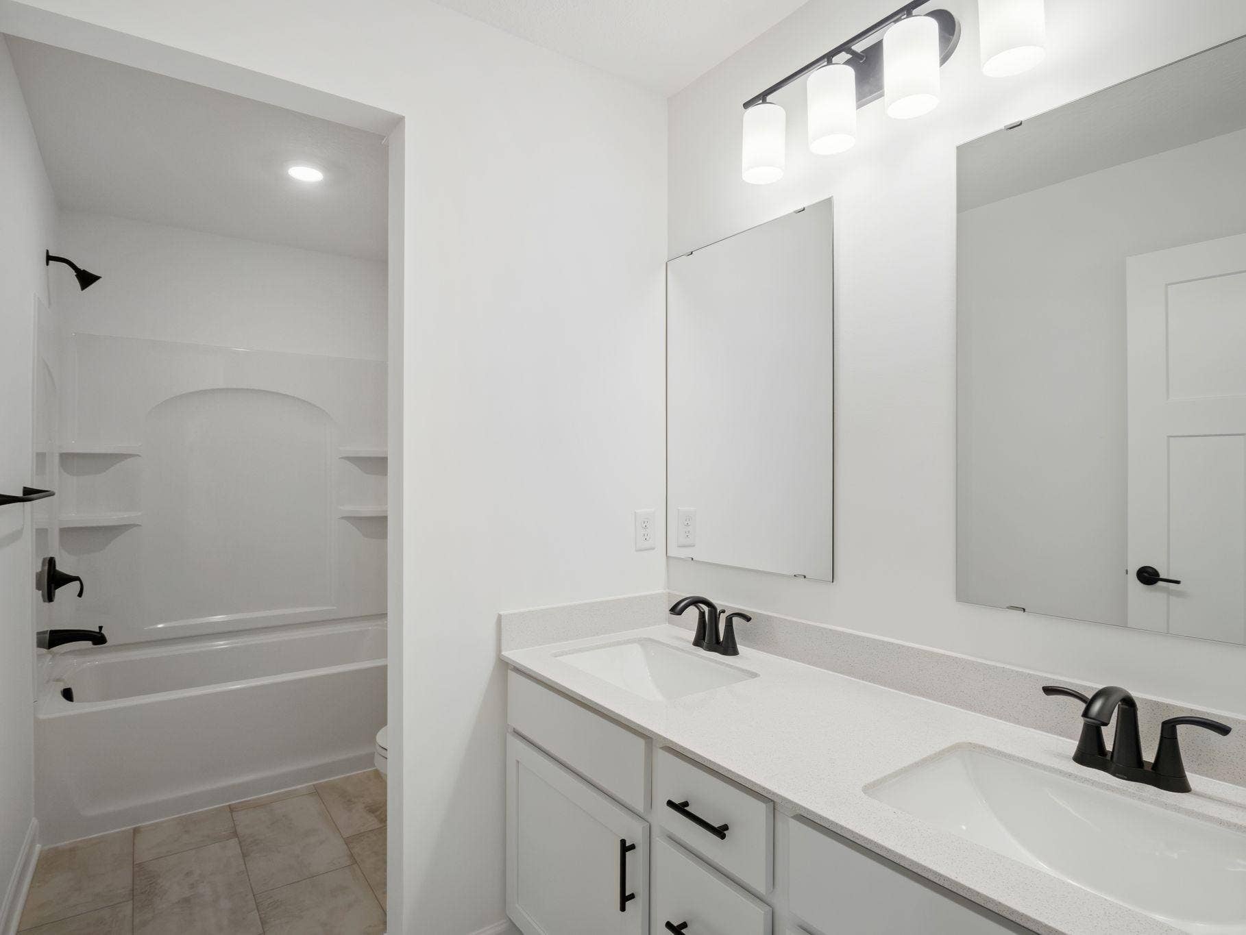 8656 Periwinkle Boulevard, Woodbury, MN 55129 This full bathroom is conveniently located on the second floor and showcases dual sinks and a shower-tub combination.
