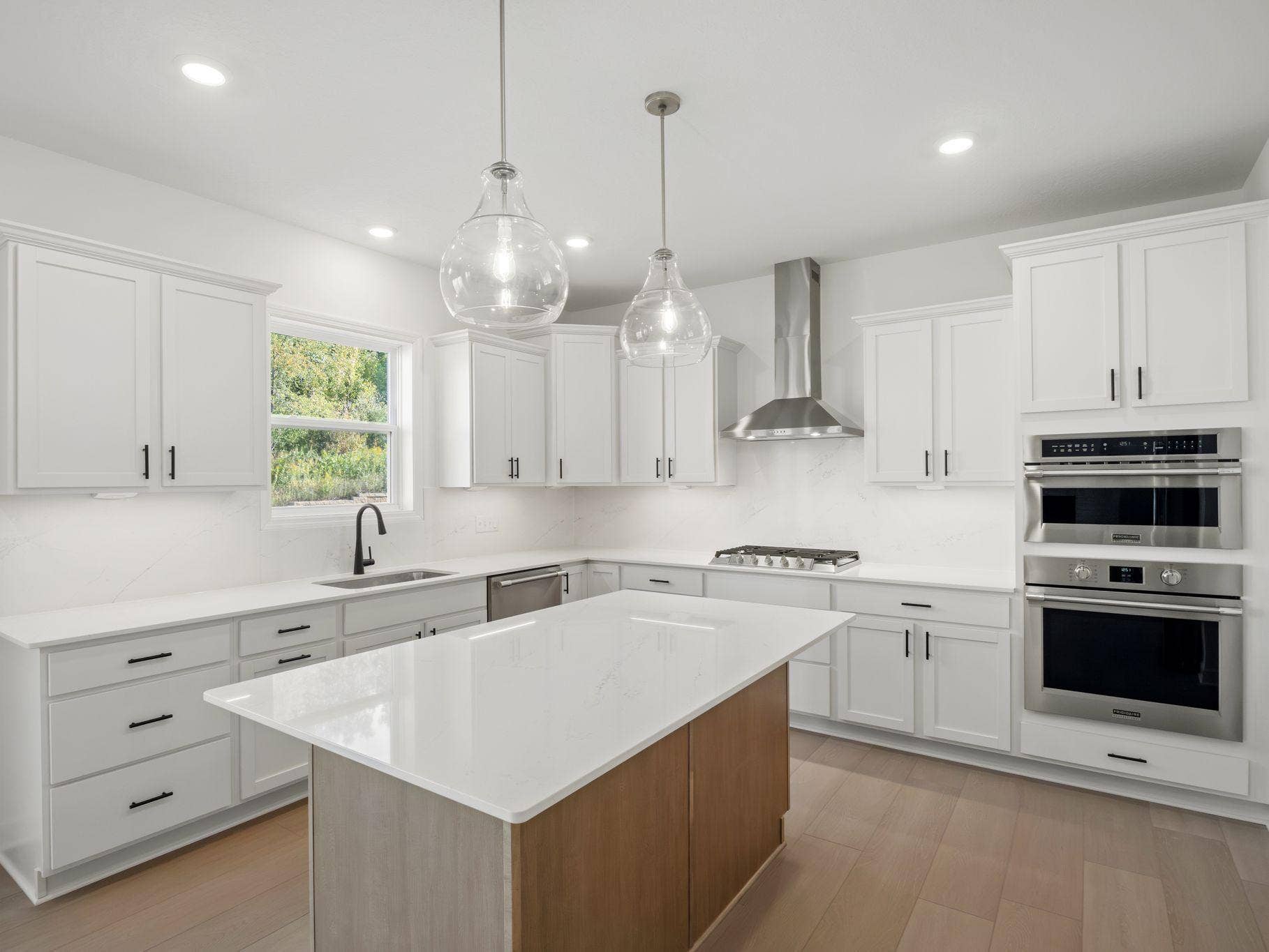 8656 Periwinkle Boulevard, Woodbury, MN 55129 This stylish kitchen showcases a large center island, Shaker-style cabinetry, and brand-new stainless-steel appliances.